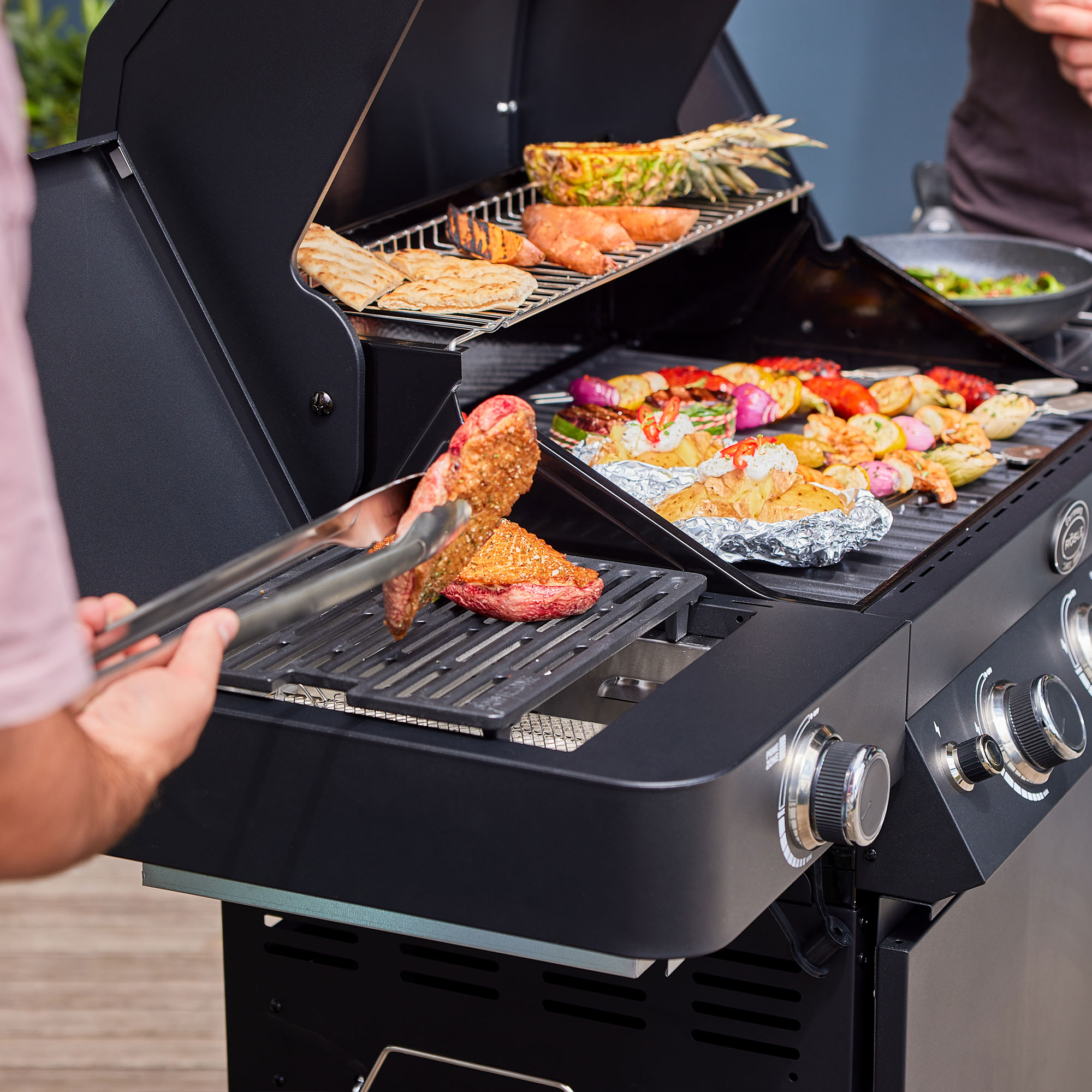 RÖSLE Gasgrill Videro G3-S Gasgrill Videro G3-S in Schwarz mit Grillgut wie Fleisch, Gemüse und Fisch auf dem Rost.