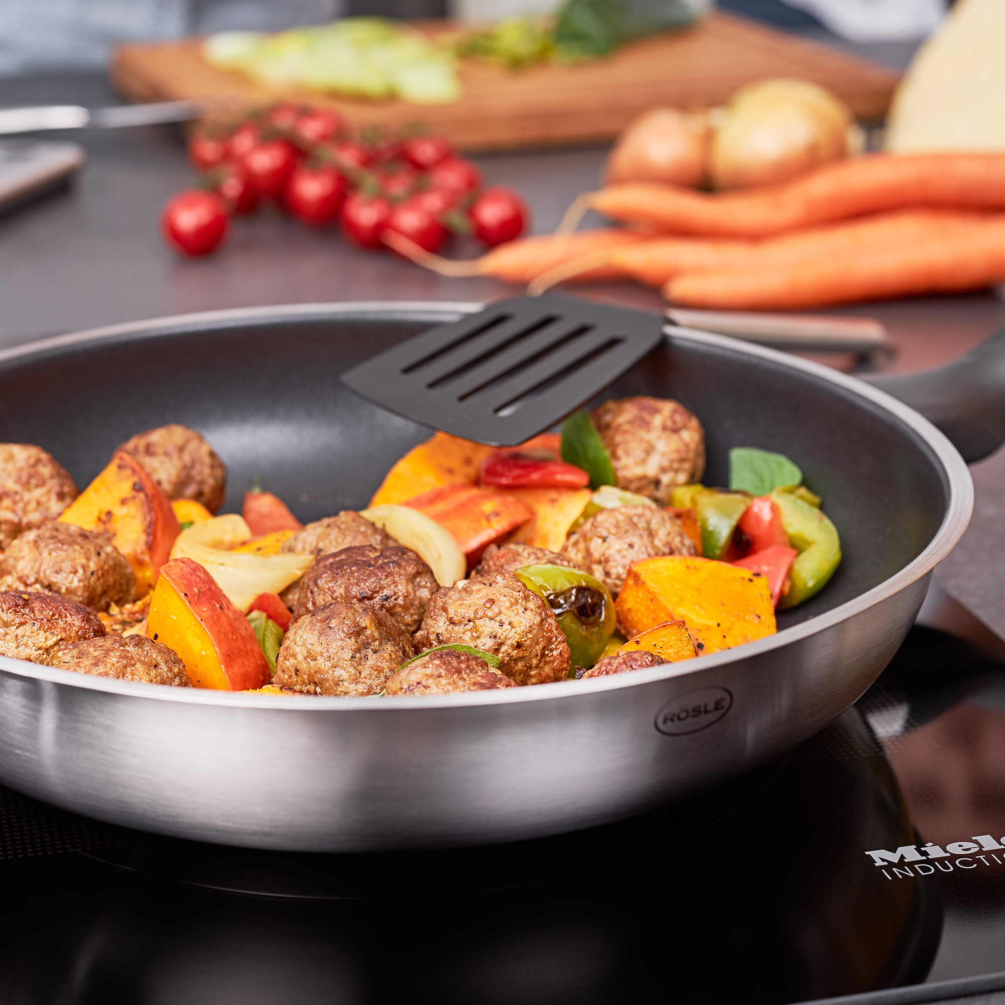 RÖSLE Bratpfanne mit Fleischbällchen und Gemüse Bratpfanne 28 cm aus der ProPlex Basic Line mit Fleischbällchen und Gemüse auf dem Herd.