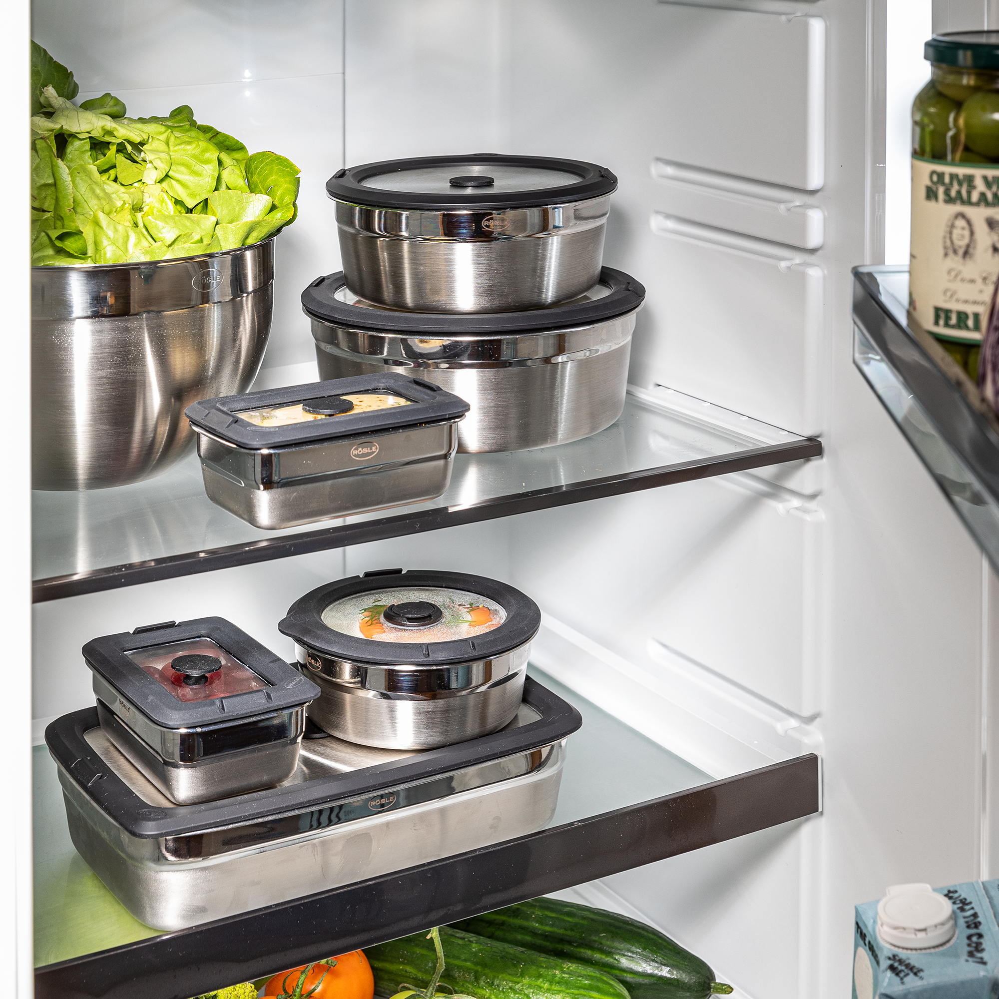 Flexx2go 1,5l Aufbewahrungsbehälter aus Edelstahl im Kühlschrank, umgeben von frischem Gemüse und Salat.