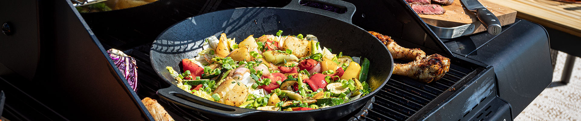 Vario+ grill grid system Wok with gnocchi vegetables in the Vario+ grill rack system on the grill.