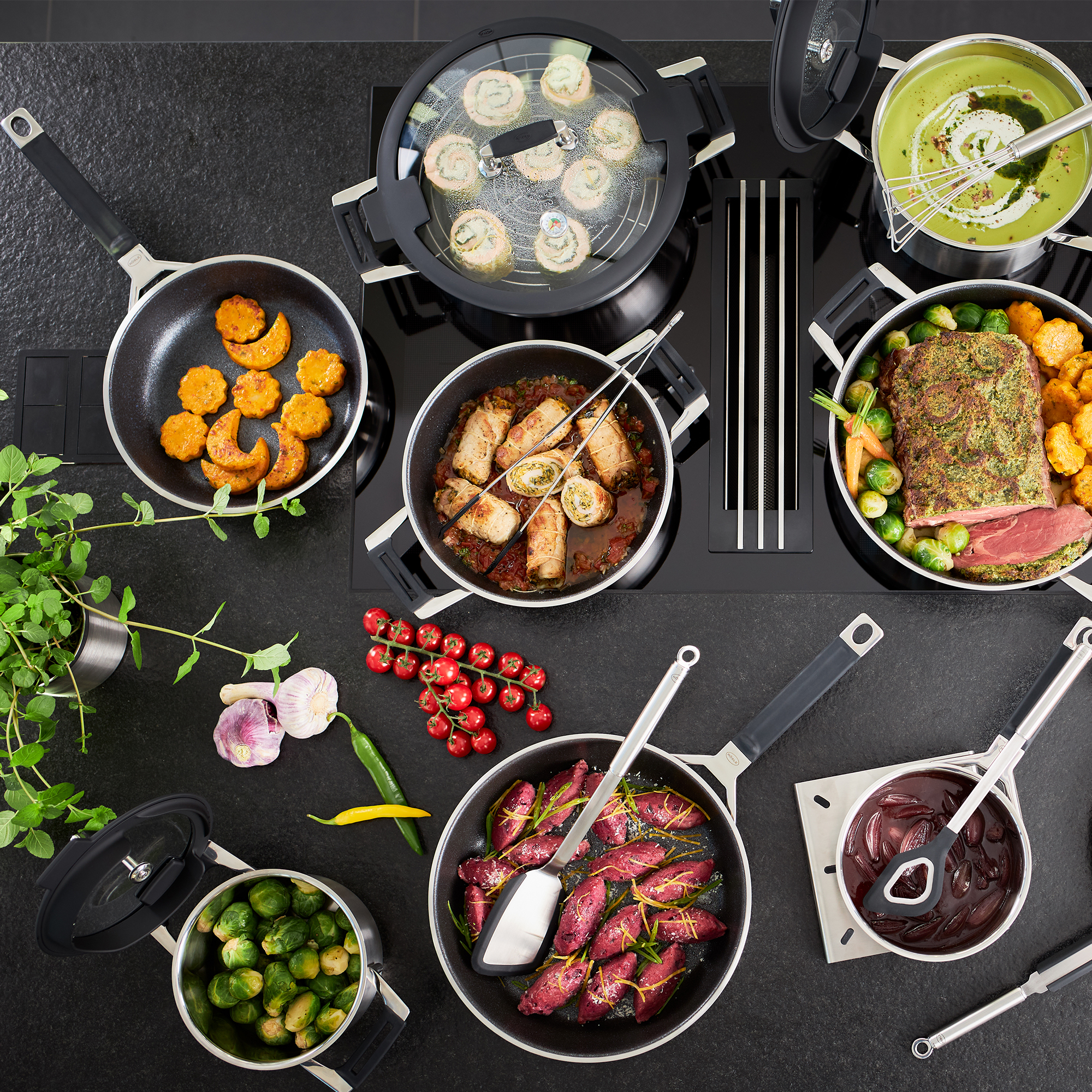 RÖSLE Aroma steamer and braising pan with various dishes Aroma steamer and stew pan in various sizes with vegetables, meat and side dishes on one hob.