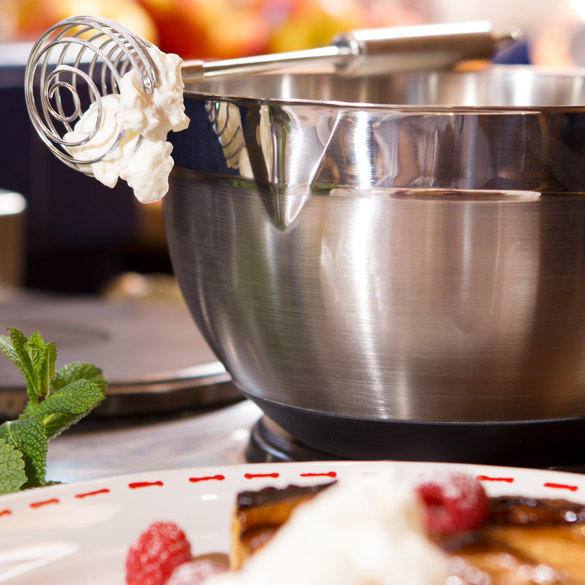 RÖSLE whisk 22 cm Stainless steel whisk, 22 cm, with cream on the tip, in a bowl.