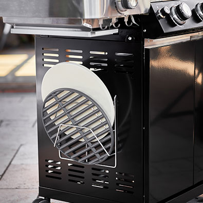 Holder for grills Pizza stone and cast iron grill in the holder on the side of the grll