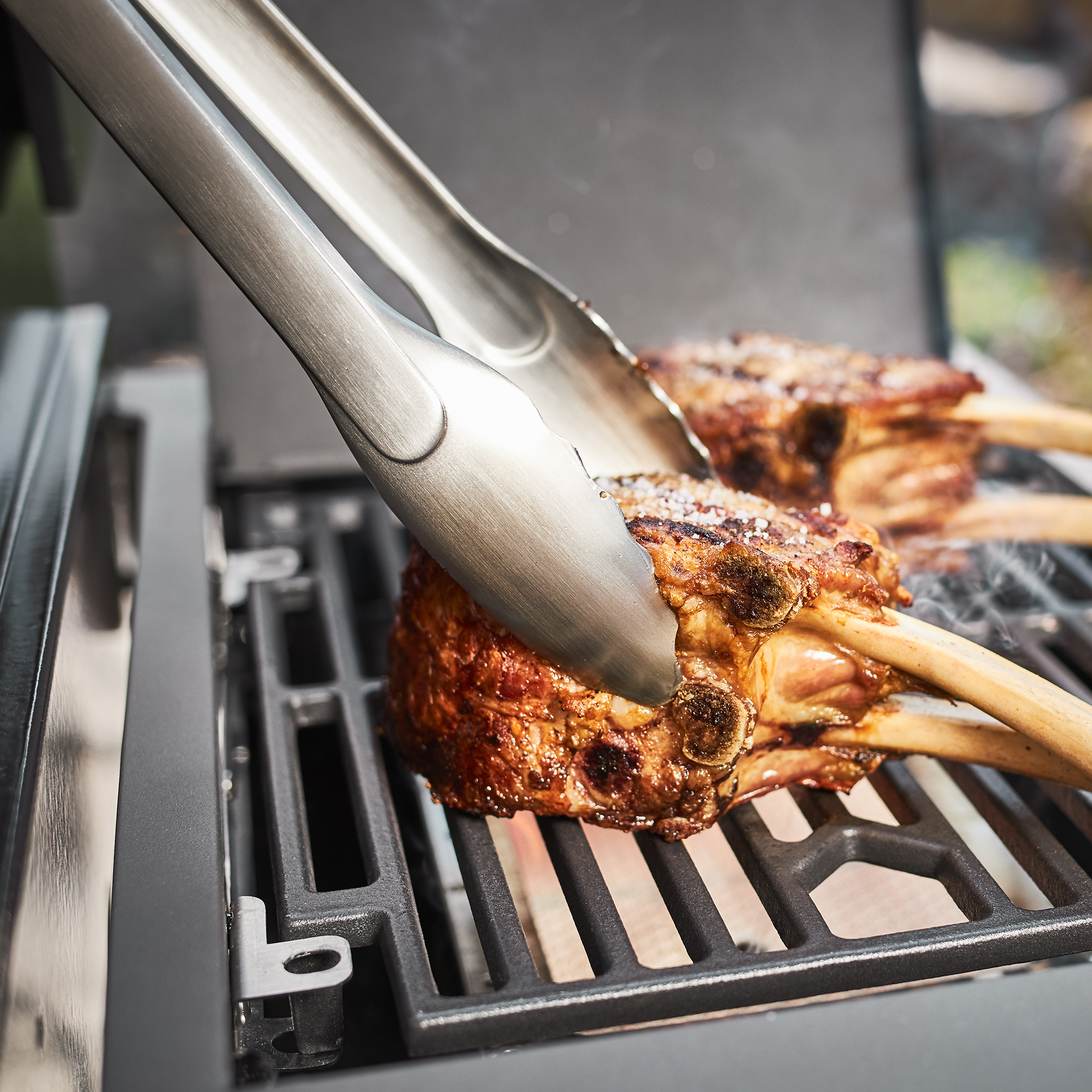 RÖSLE Grillzange 40 cm Grillzange aus Edelstahl, 40 cm, greift gegrillte Lammkoteletts auf einem Grillrost.