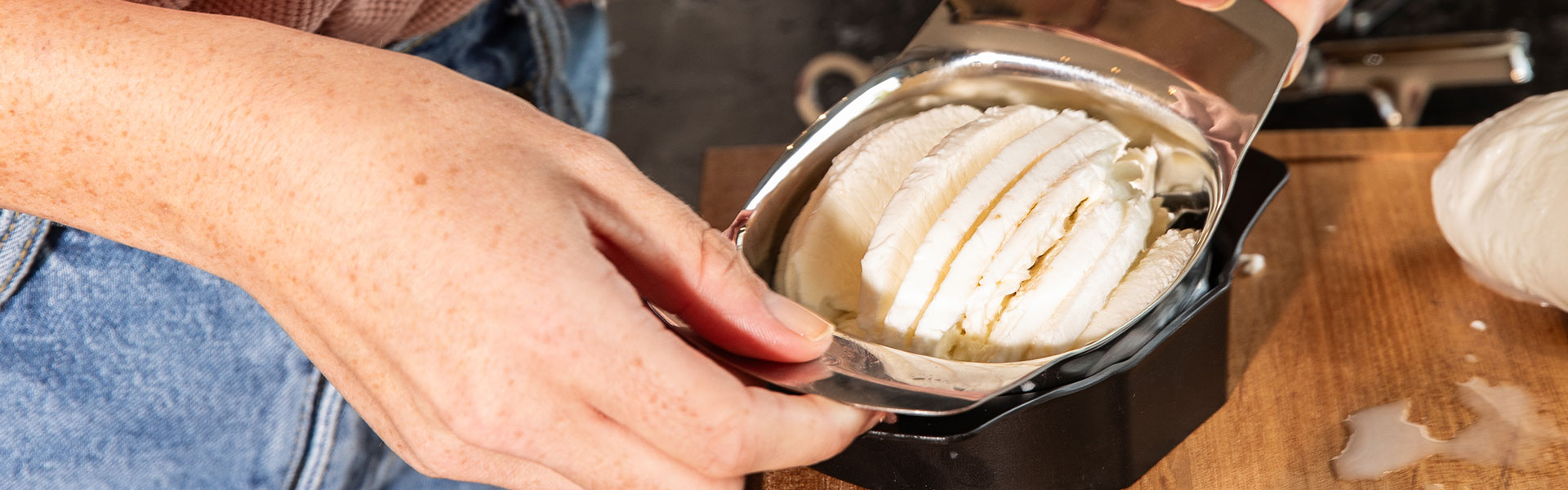 Eiskelle von RÖSLE in Aktion Eiskelle aus Edelstahl, die eine Portion Eis aus einem Behälter schöpft.