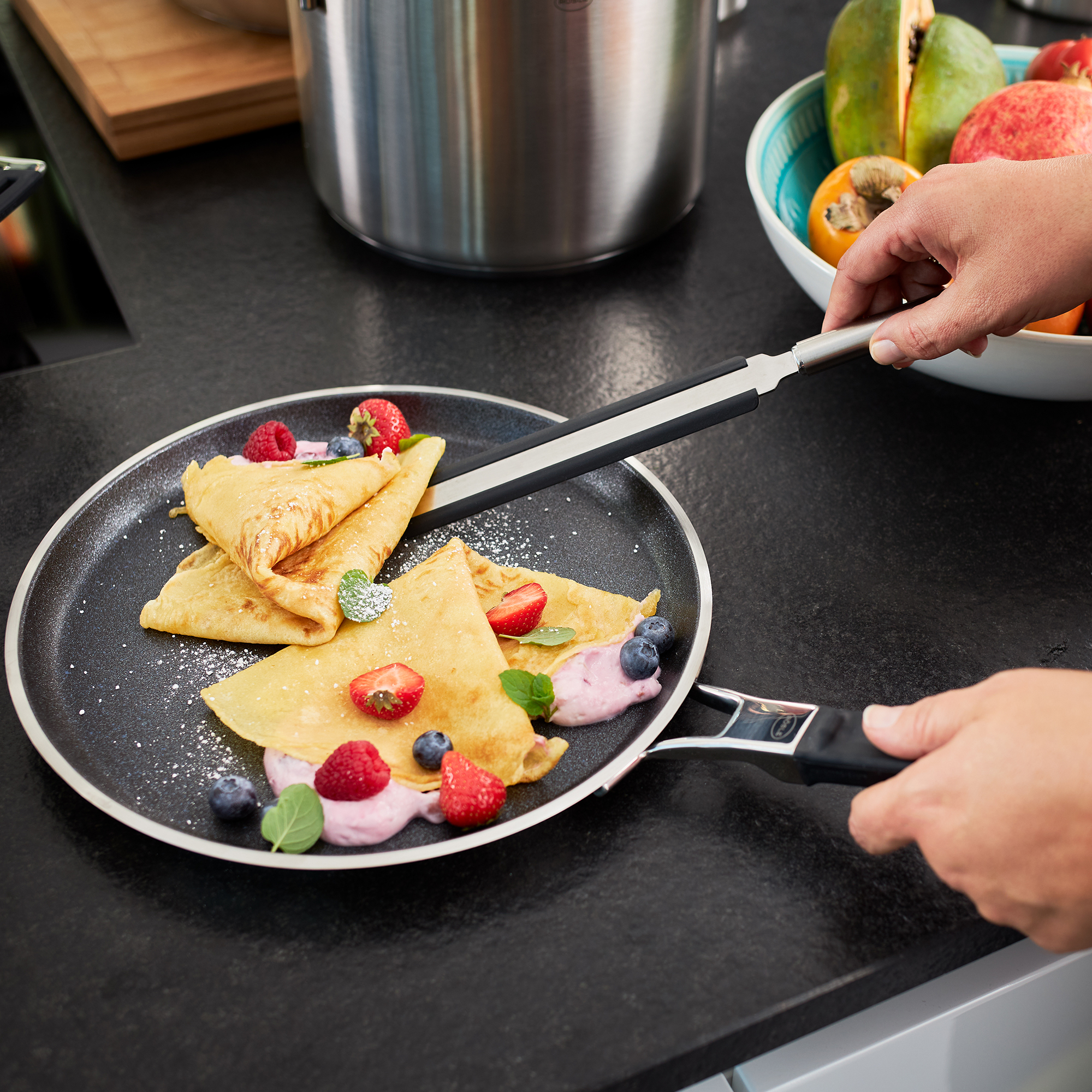 RÖSLE silicone crepe turner in action Crepes turner made of silicone, for turning crepes on a pan, with fresh berries and yoghurt.