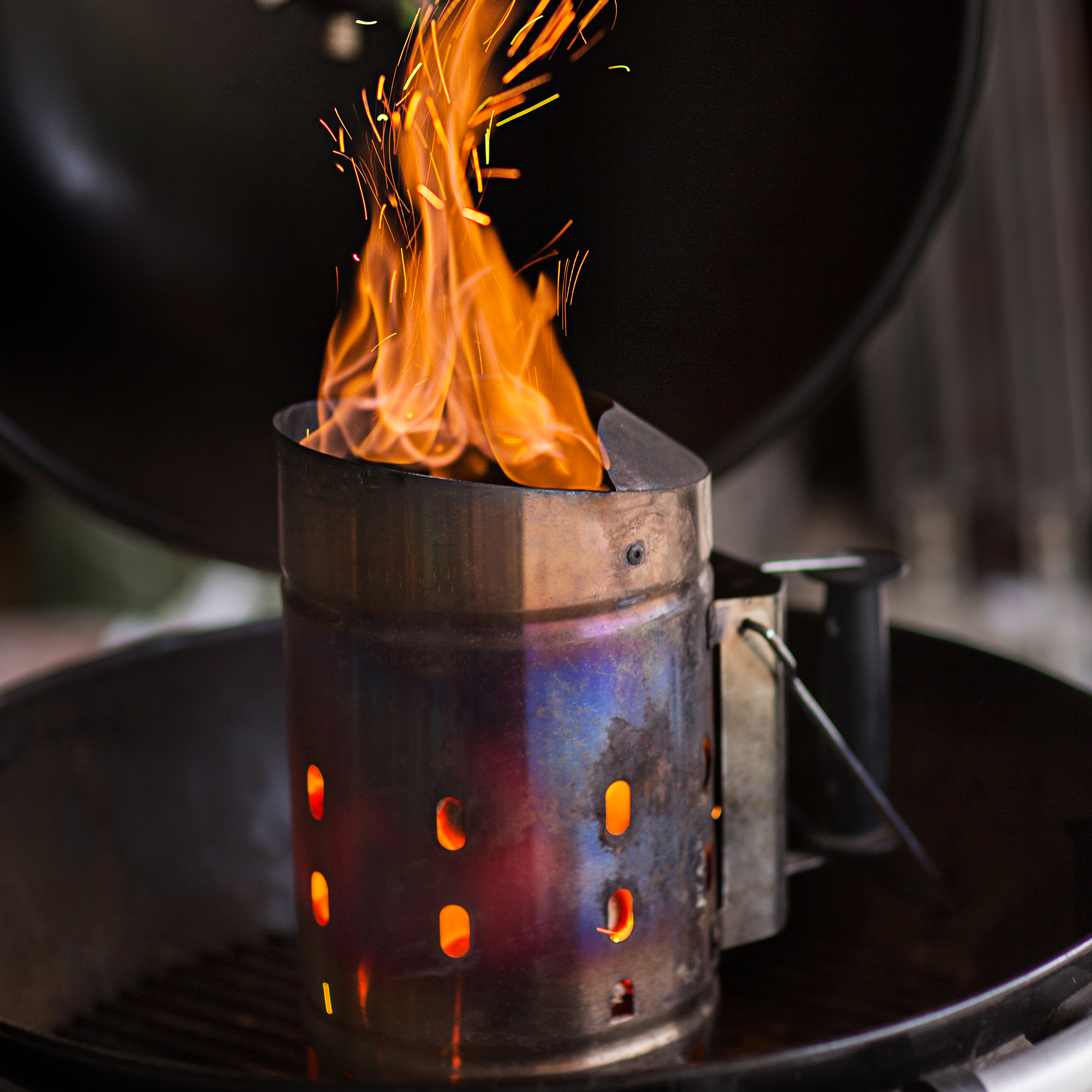 Edelstahl Anzündkamin von RÖSLE mit Feuer Anzündkamin aus Edelstahl mit loderndem Feuer und Funken.