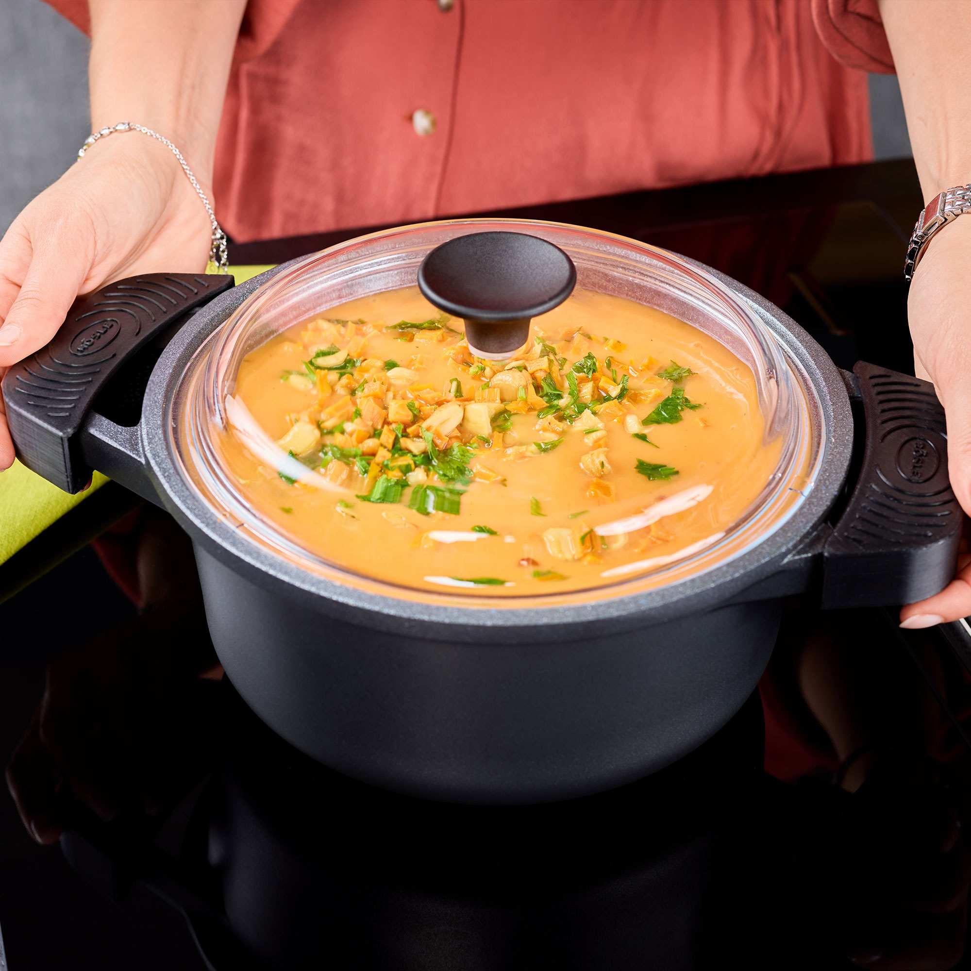 RÖSLE Kochtopf mit Silikongriffen und Suppe Kochtopf mit Silikongriffen, gefüllt mit einer cremigen Suppe und frischen Kräutern, von einer...