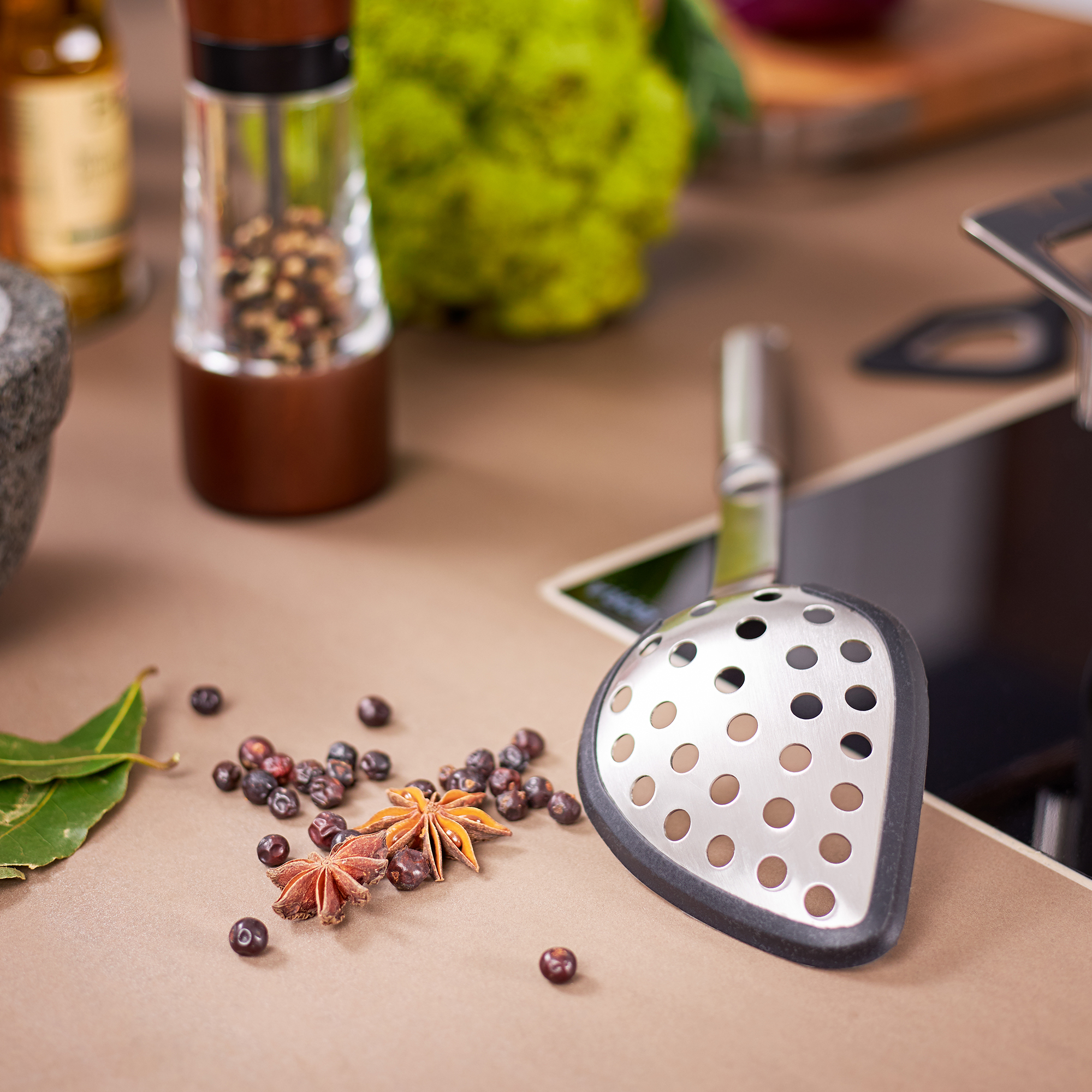 RÖSLE silicone multifunctional spoon Multifunctional silicone spoon with perforated pattern, on a work surface with spices and...
