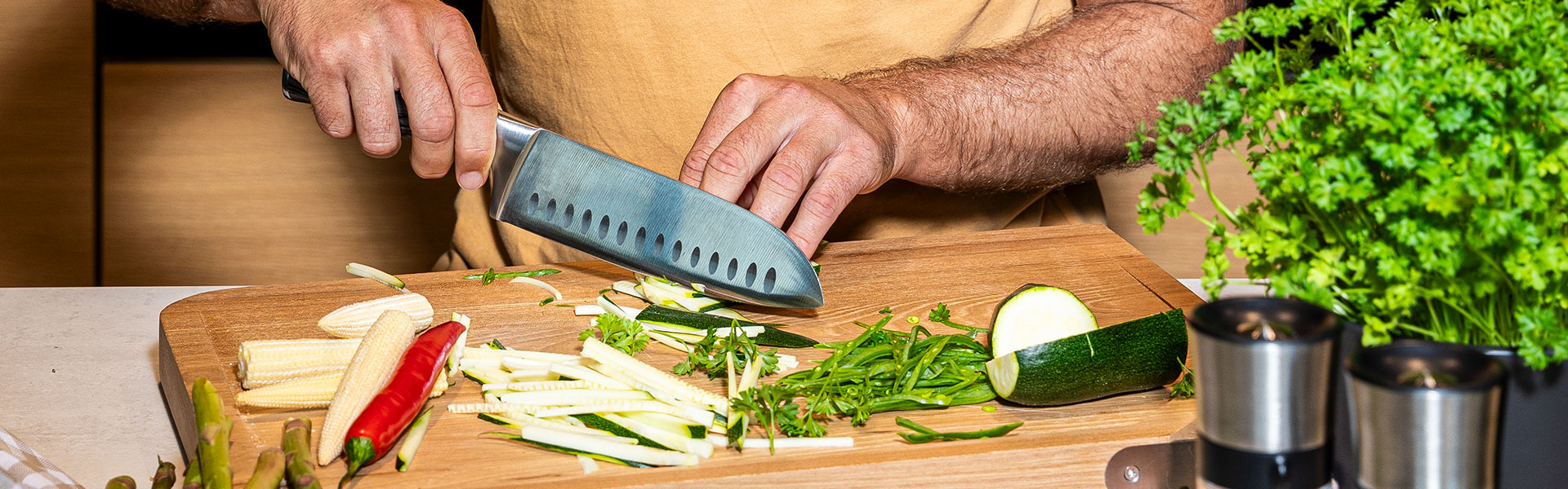 RÖSLE Kochmesser mit Gemüse Kochmesser, Edelstahl, beim Schneiden von Gemüse auf einem Holzbrett.