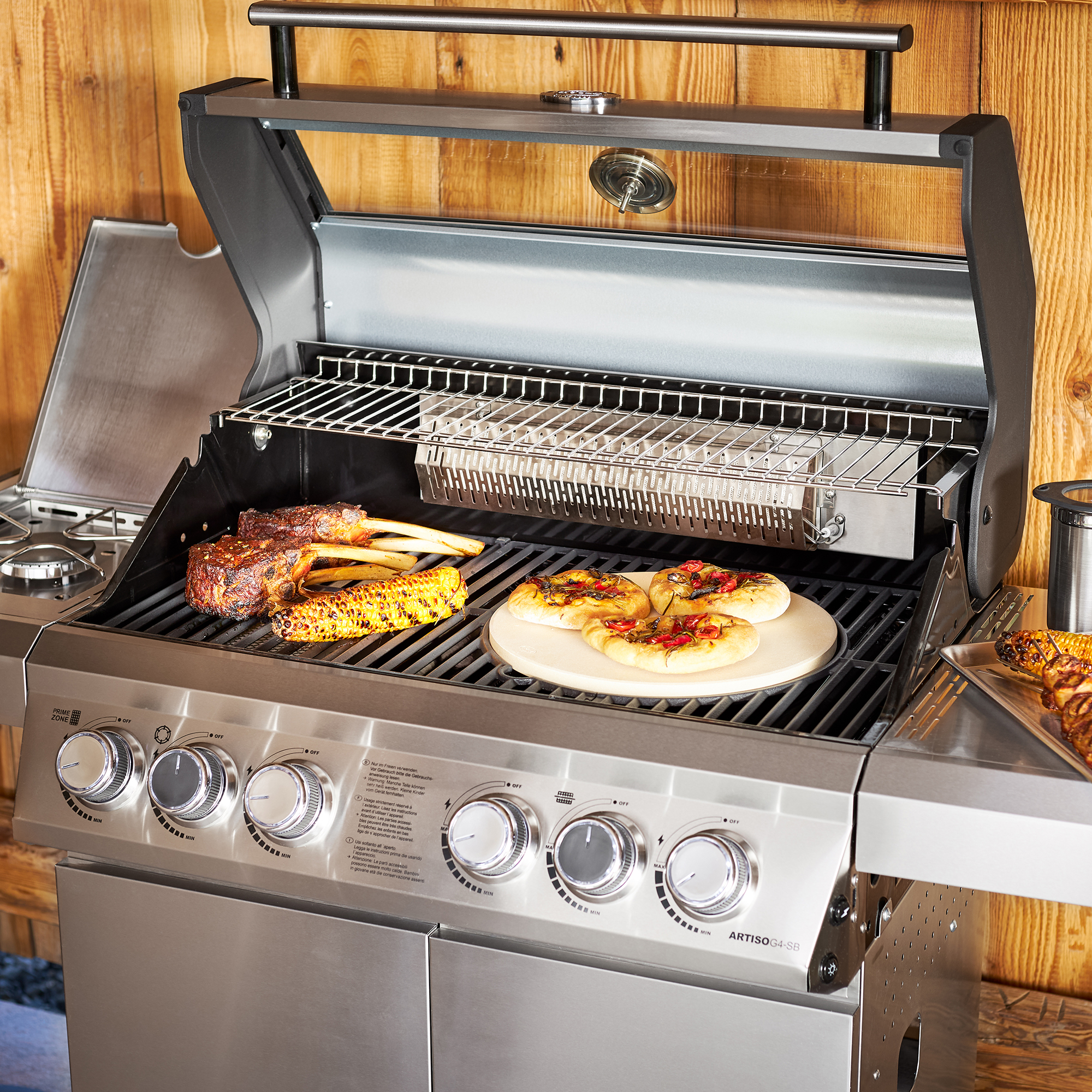 RÖSLE Gasgrill Artiso G4-SB Gasgrill Artiso G4-SB aus Edelstahl mit Grillrost, Fleisch und Gemüse auf dem Grill.