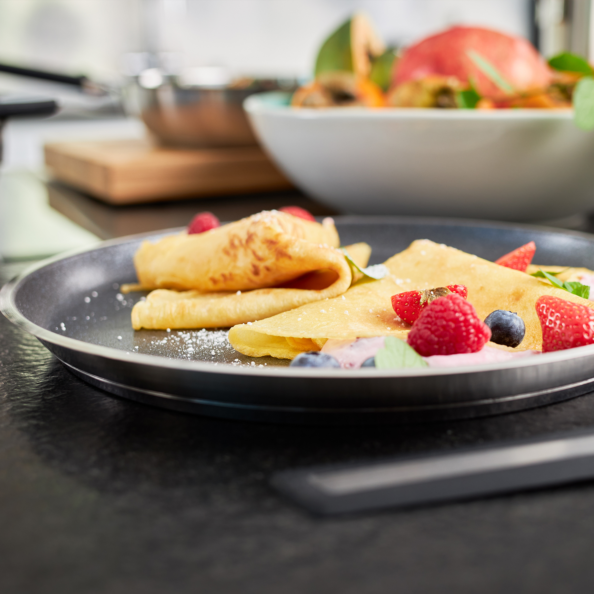 RÖSLE crepes pan with crepes and berries Crepes pan, 28 cm, with crepes and fresh berries on a plate.