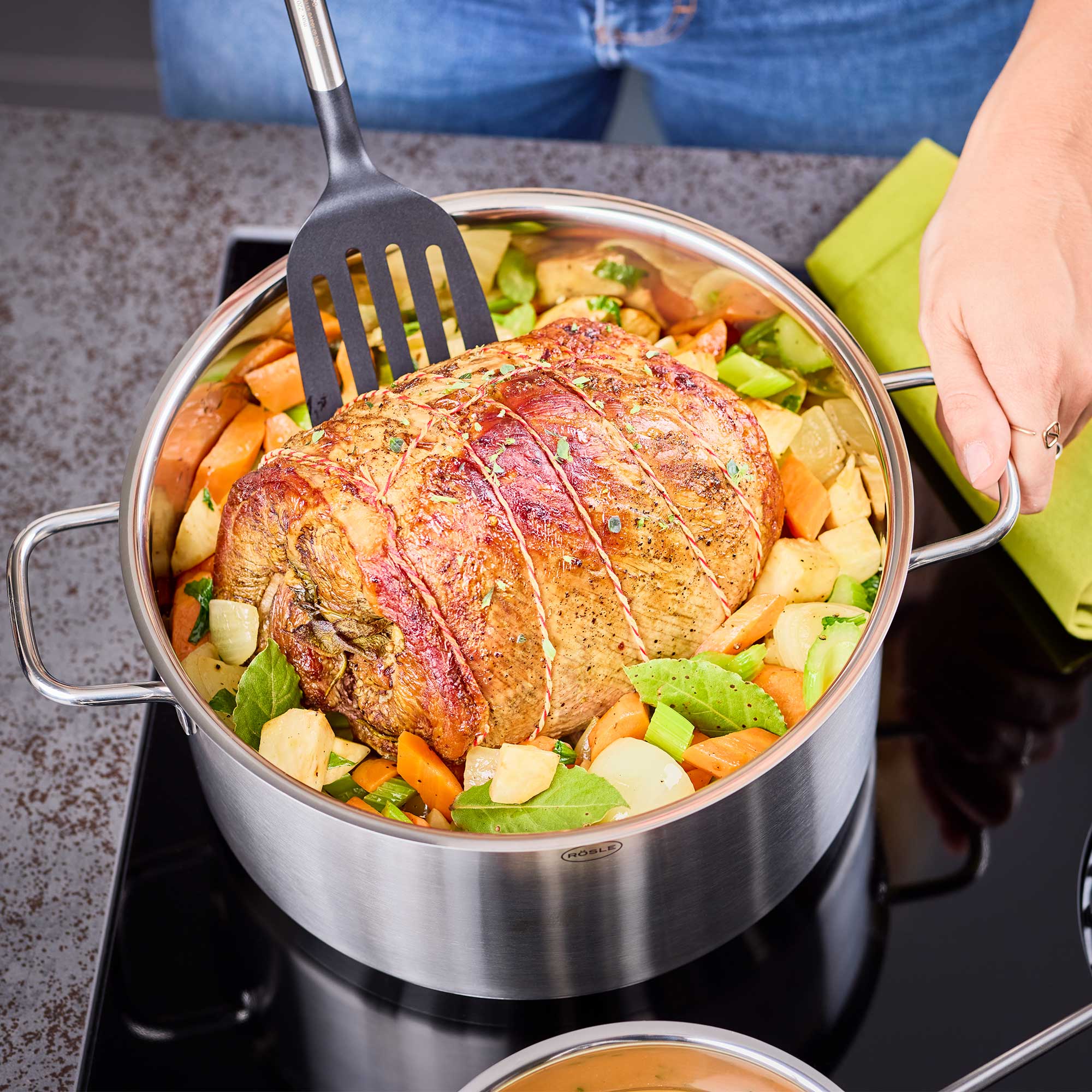 RÖSLE Topf Set Basic Line mit Braten Topf Set Basic Line mit einem Braten und Gemüse auf dem Herd.