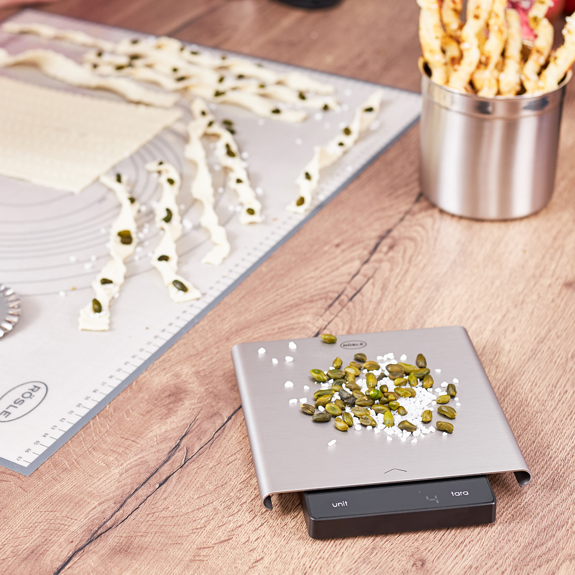 Digitale Küchenwaage von RÖSLE digitale Küchenwaage mit Slide-Funktion, silber, auf einer Holzoberfläche mit Pistazien und...