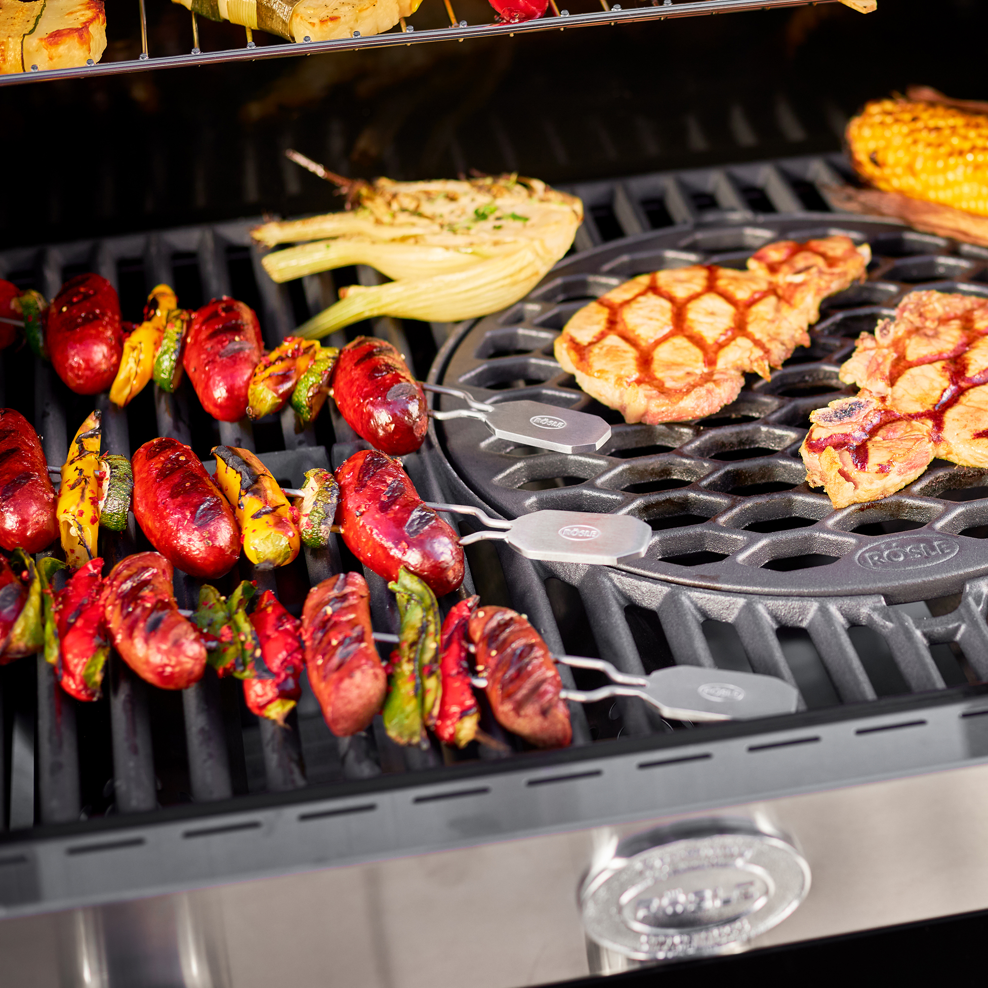 RÖSLE barbecue skewers set of 4 Grill skewers in use with vegetables and meat on the grill rack.