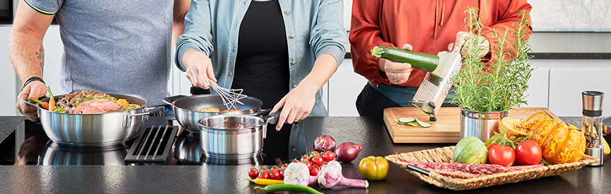 Schneiden einer Zucchini mit der Multifunktionsreibe und kochen am Herd in der Silence Pro Servierpfanne und Stielkasserolle mit dem Gourmetbesen