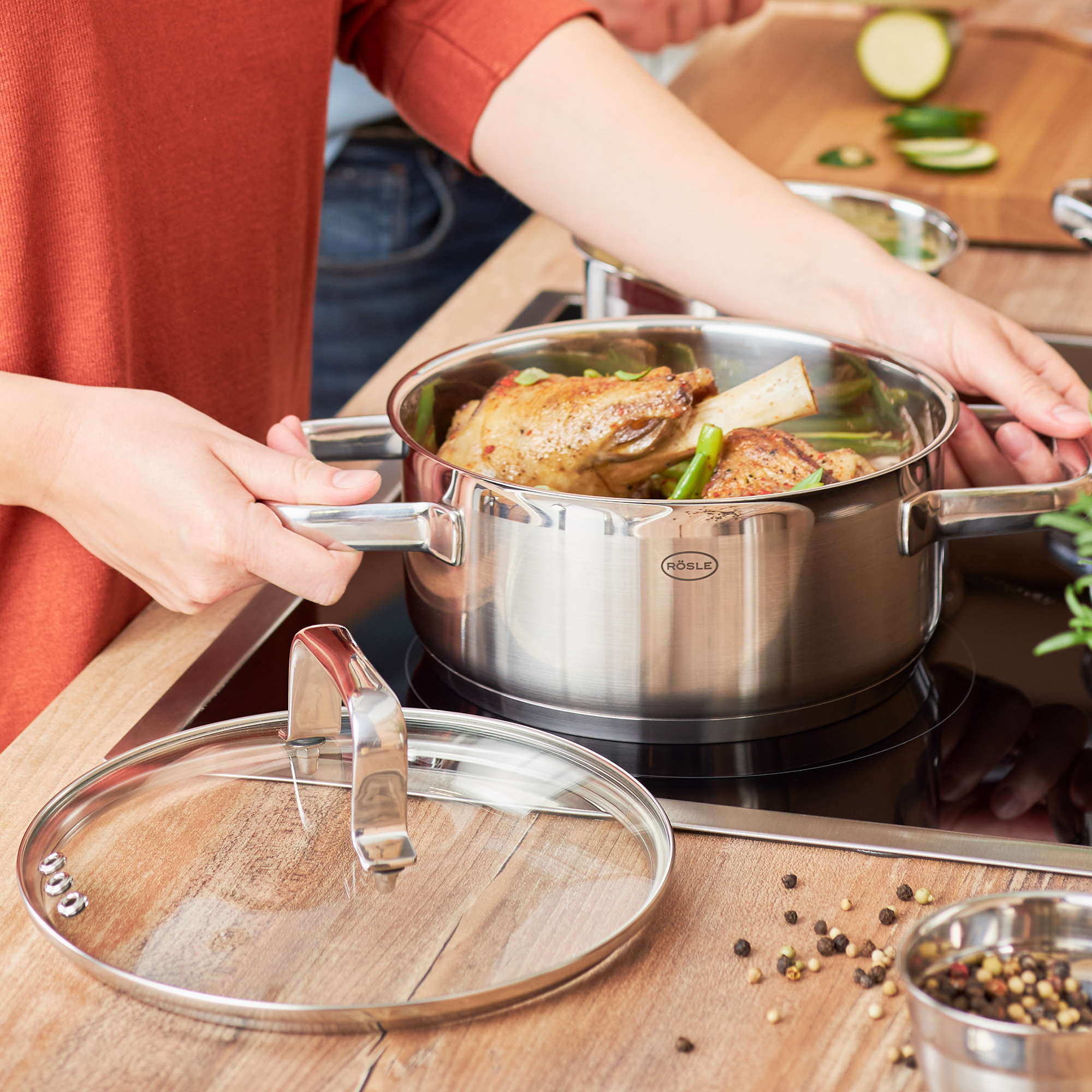 RÖSLE roasting pan 20 cm Stainless steel roasting pan with lid, filled with vegetables and meat, on a hob.