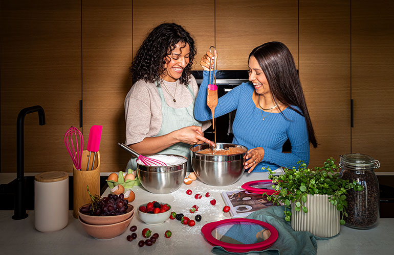 Pink Charity Freundinnen backen zusammen mit den pinken Backhelfern der Pink Charity Edition.