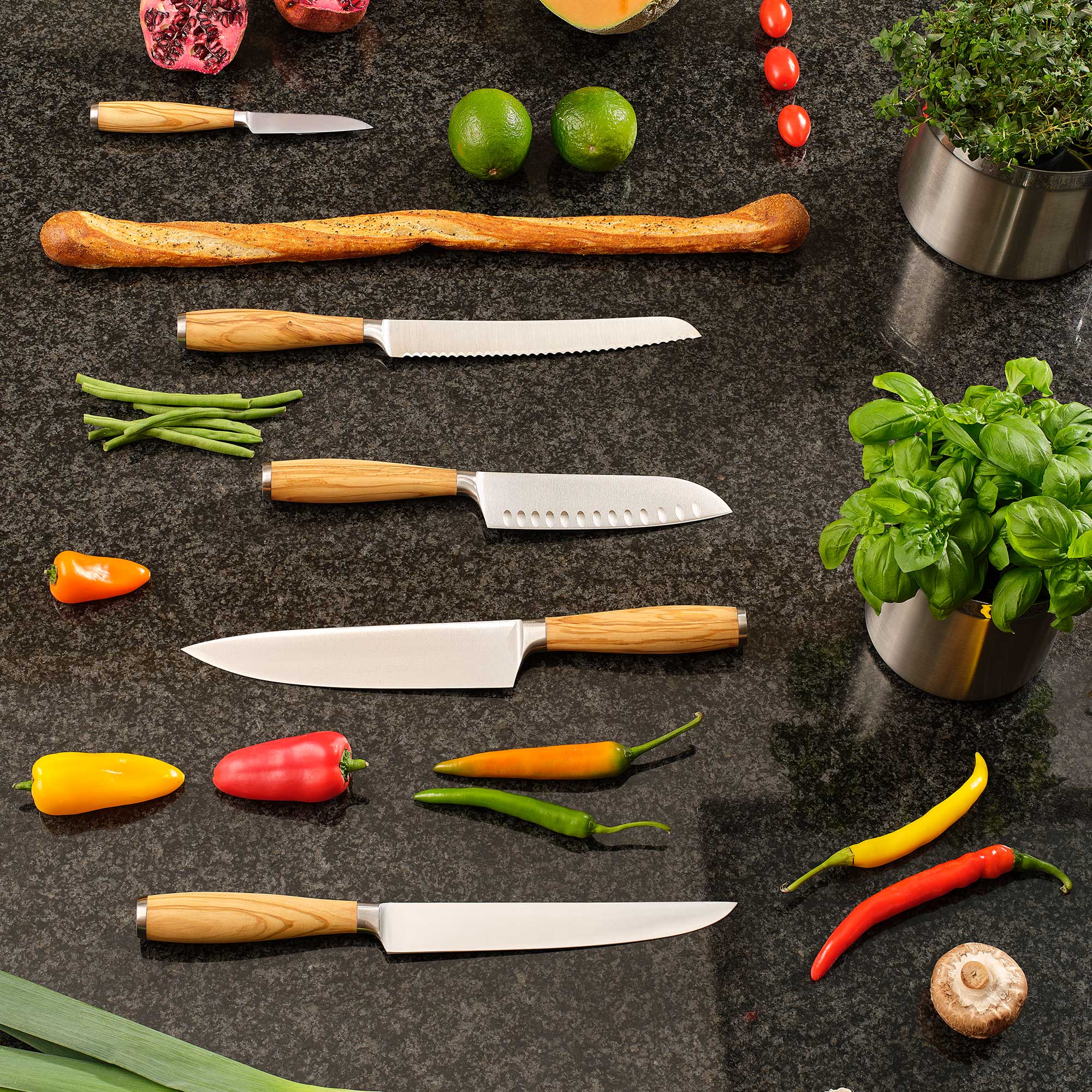 RÖSLE Santokumesser 16 cm mit Holzgriff Santokumesser 16 cm aus Edelstahl mit Holzgriff, umgeben von frischem Gemüse und Kräutern...
