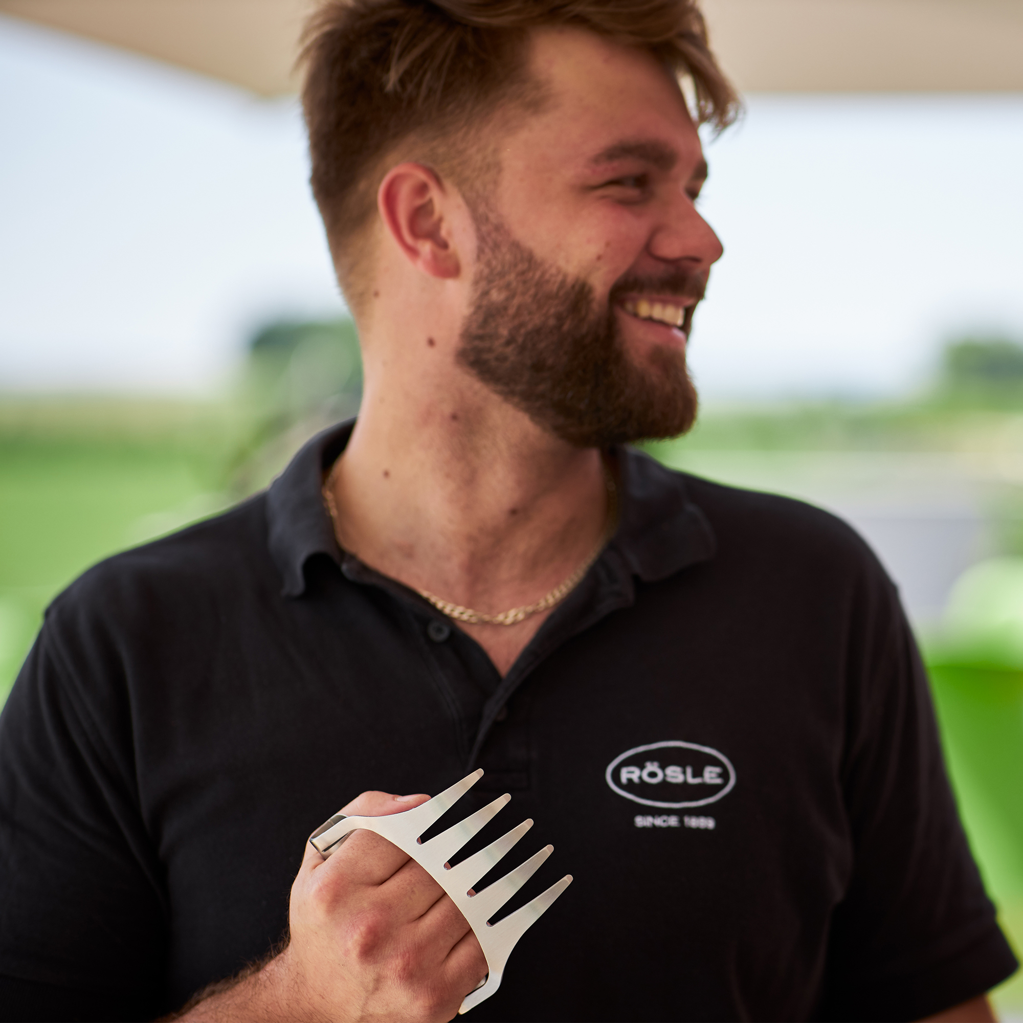Man with RÖSLE Pulled Pork Forks Stainless steel pulled pork forks, held by a man with a beard, smiling and wearing a black...