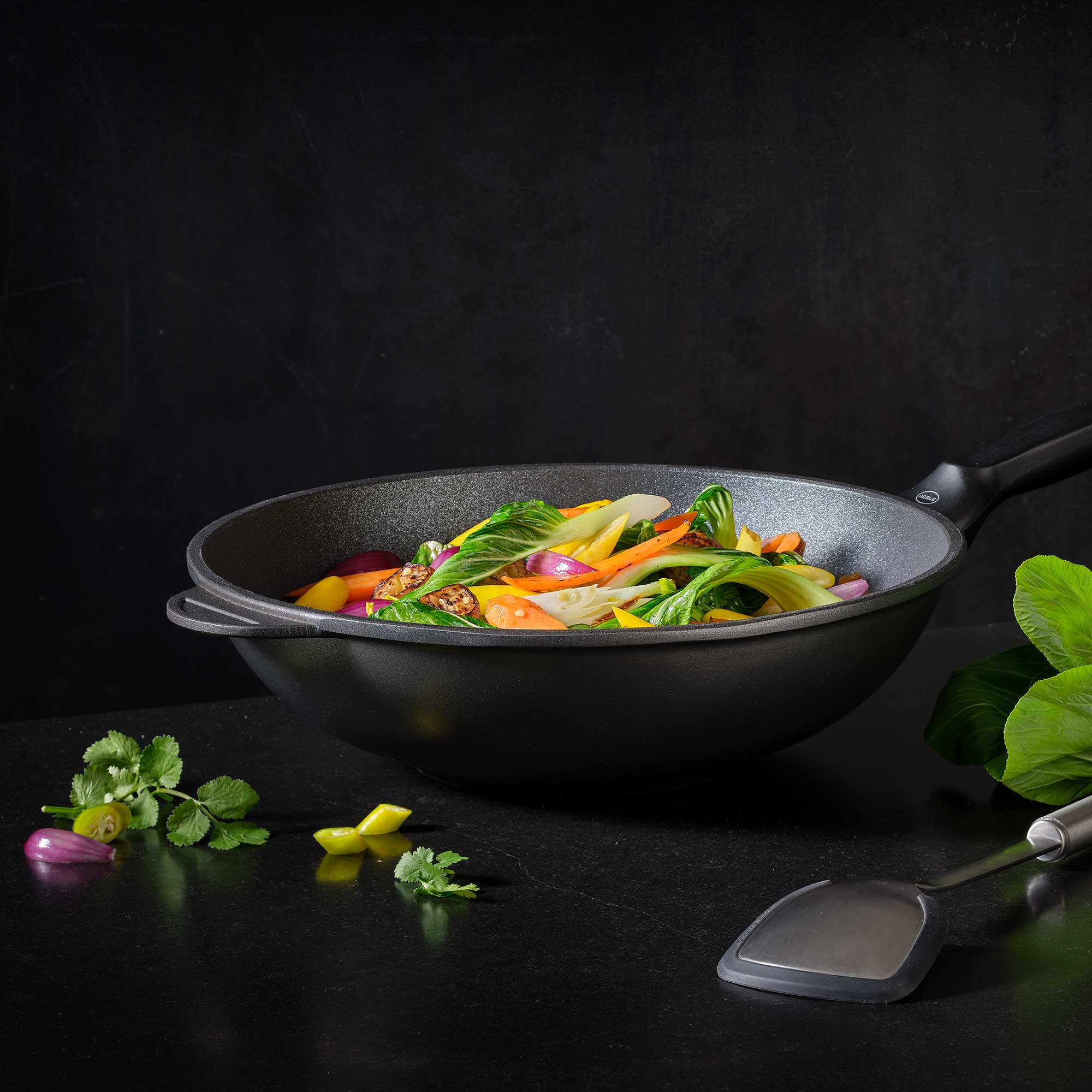 RÖSLE Wokpfanne Cadini 32 cm mit Gemüse Wokpfanne Cadini, 32 cm, aus Gusseisen, mit buntem Gemüse darin.