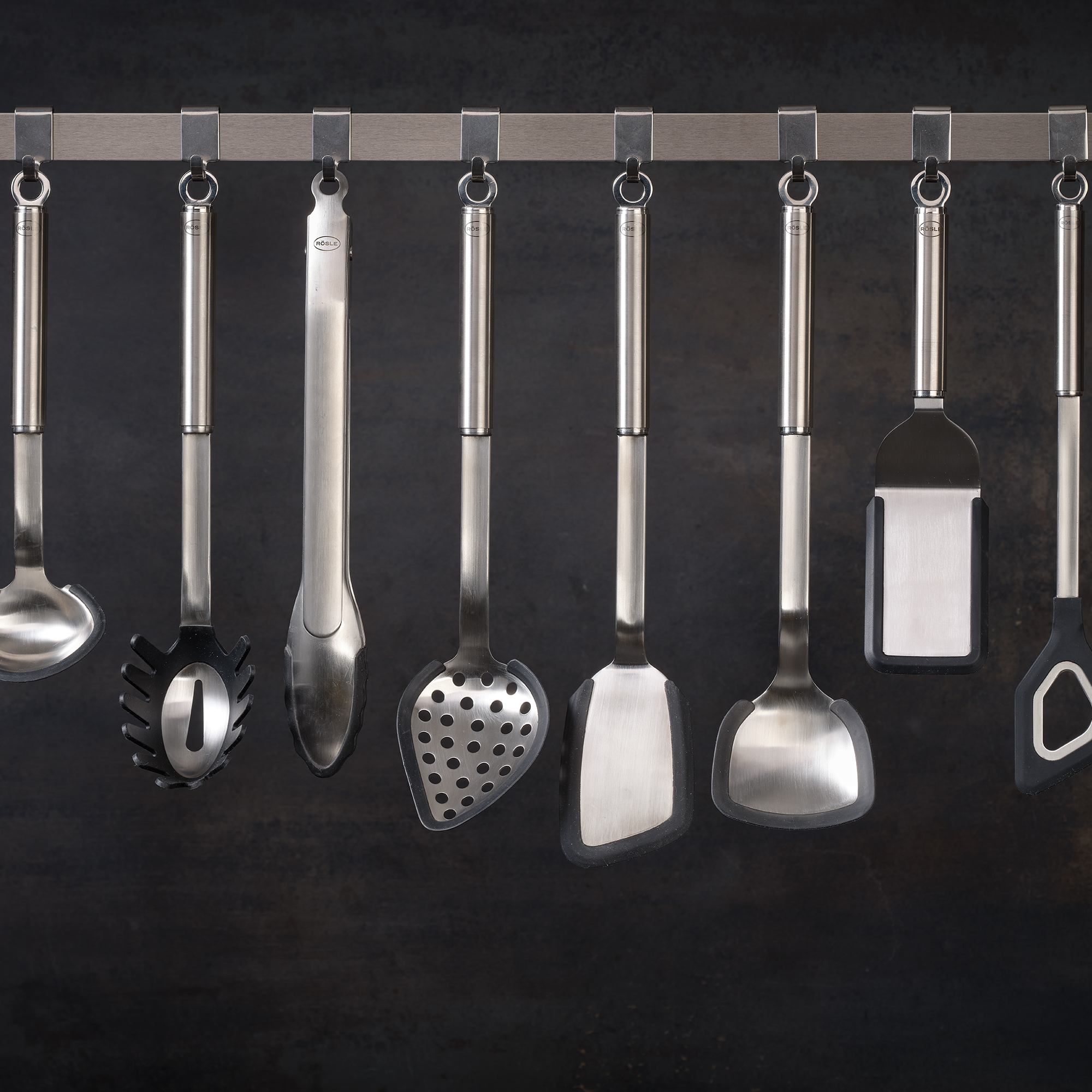 Stainless steel kitchen utensils from RÖSLE Stainless steel kitchen utensils, including ladle, turner and colander, on a hanger.