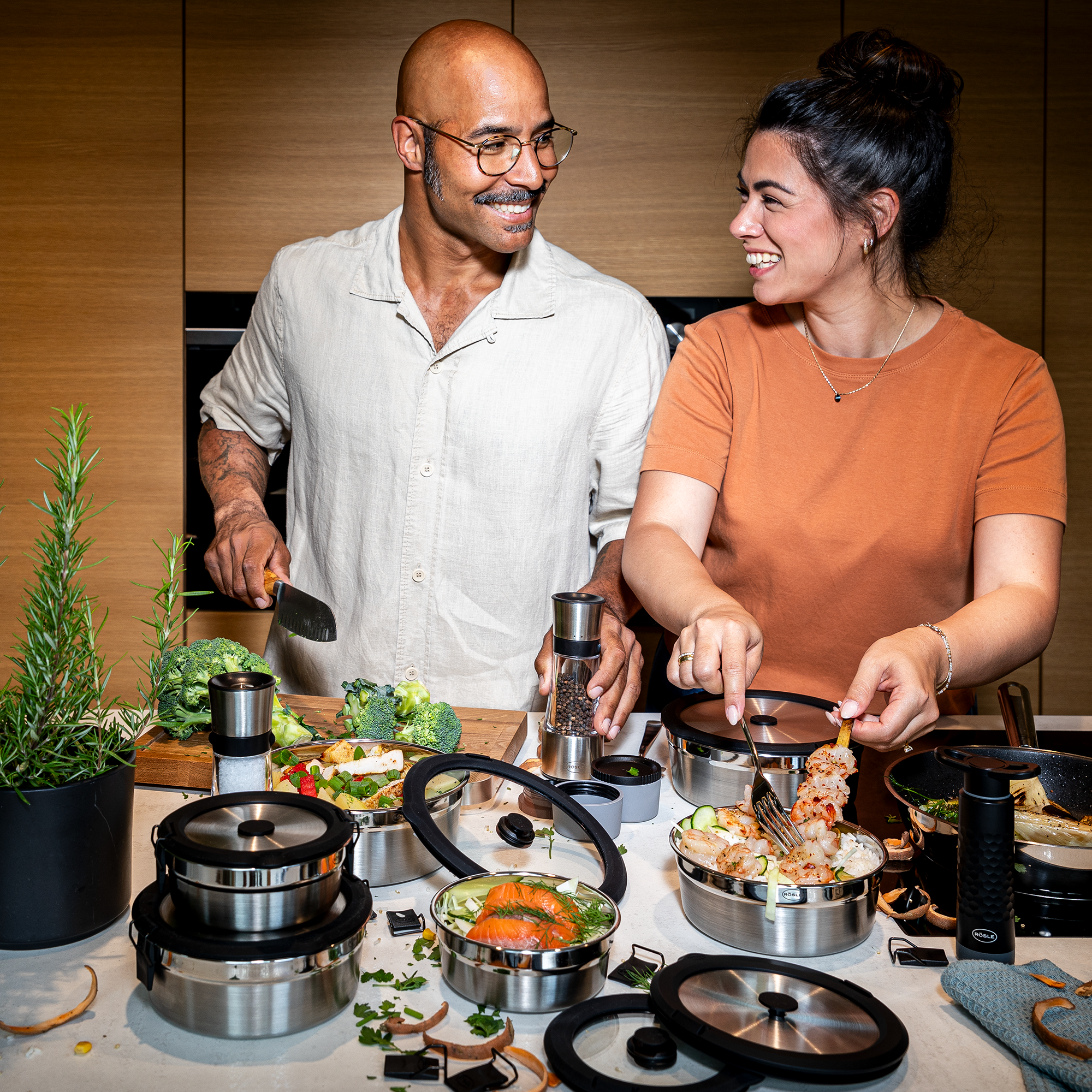 Zwei Personen in einer modernen Küche bereiten gemeinsam eine Mahlzeit vor, umgeben Flexx2go Behältern.