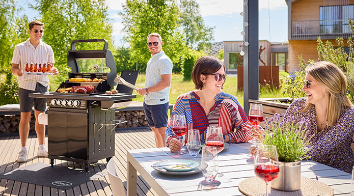 Vier Freunde grillen zusammen auf der Terrasse