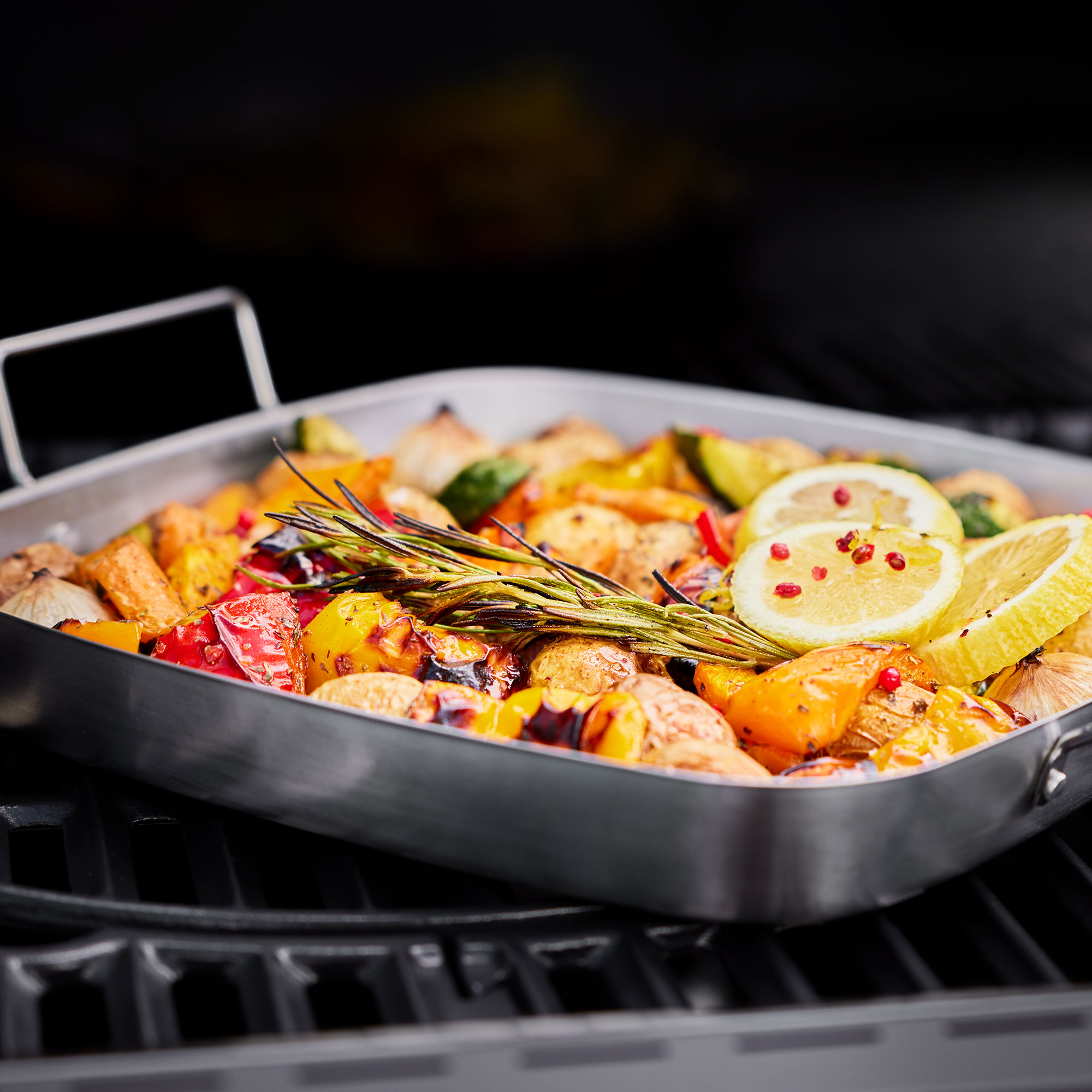 Edelstahl Schale mit gegrilltem Gemüse Edelstahl Schale mit gegrilltem Gemüse und Zitronenscheiben auf einem Grillrost.