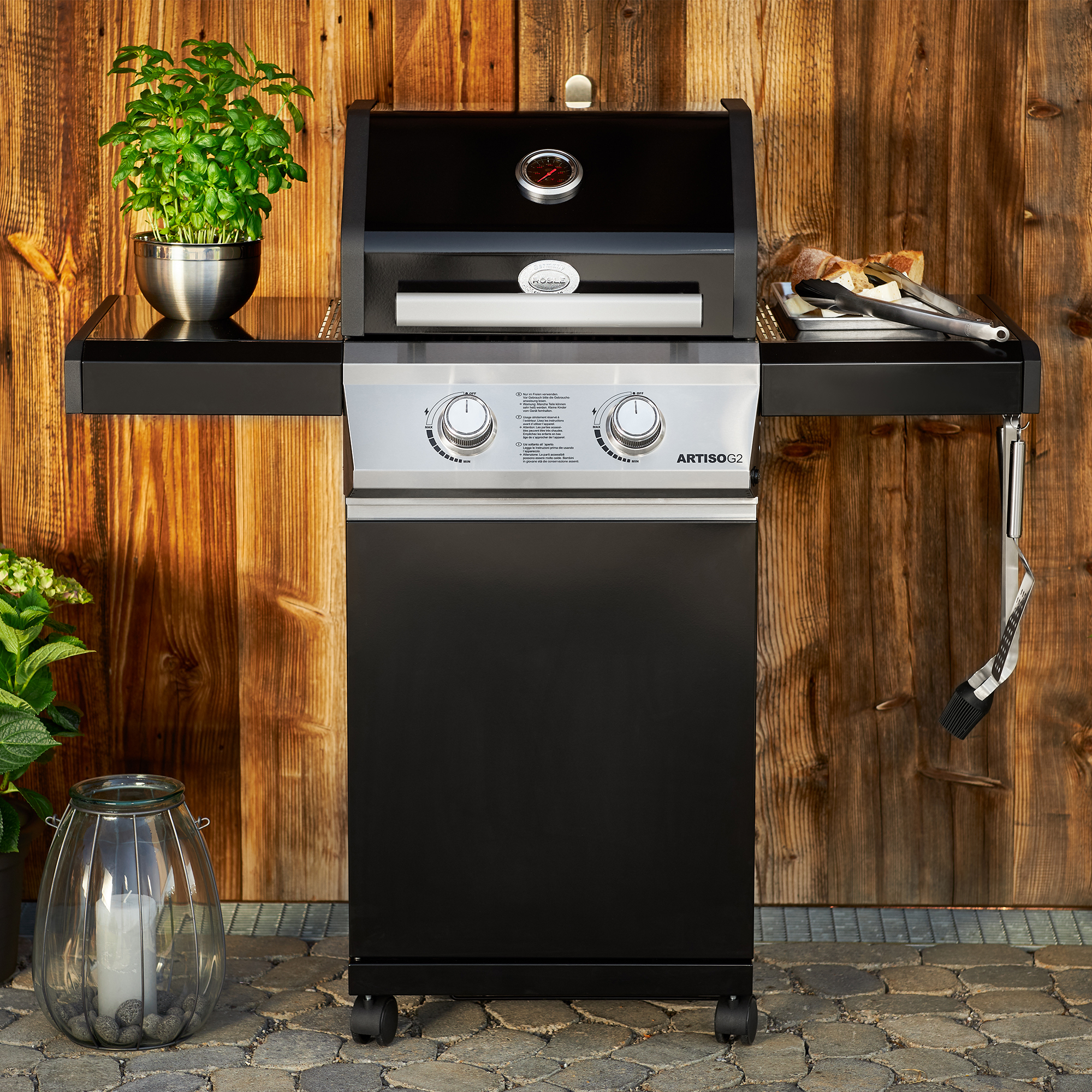 RÖSLE Gasgrill Artiso G2 Gasgrill BBQ Station Artiso G2 in Schwarz mit zwei seitlichen Ablageflächen und Temperaturanzeige.