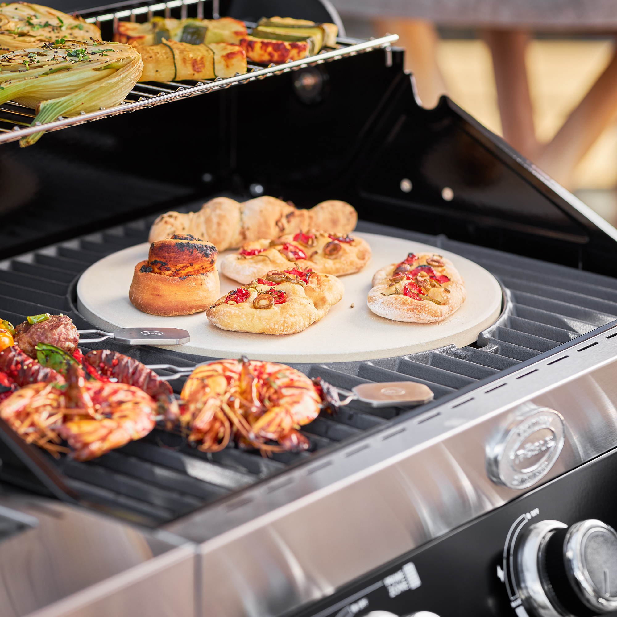 RÖSLE Gasgrill Videro G4-S mit Grillgut Gasgrill Videro G4-S in Schwarz mit Grillgut, darunter Garnelen, Fladenbrot und Gemüse auf...
