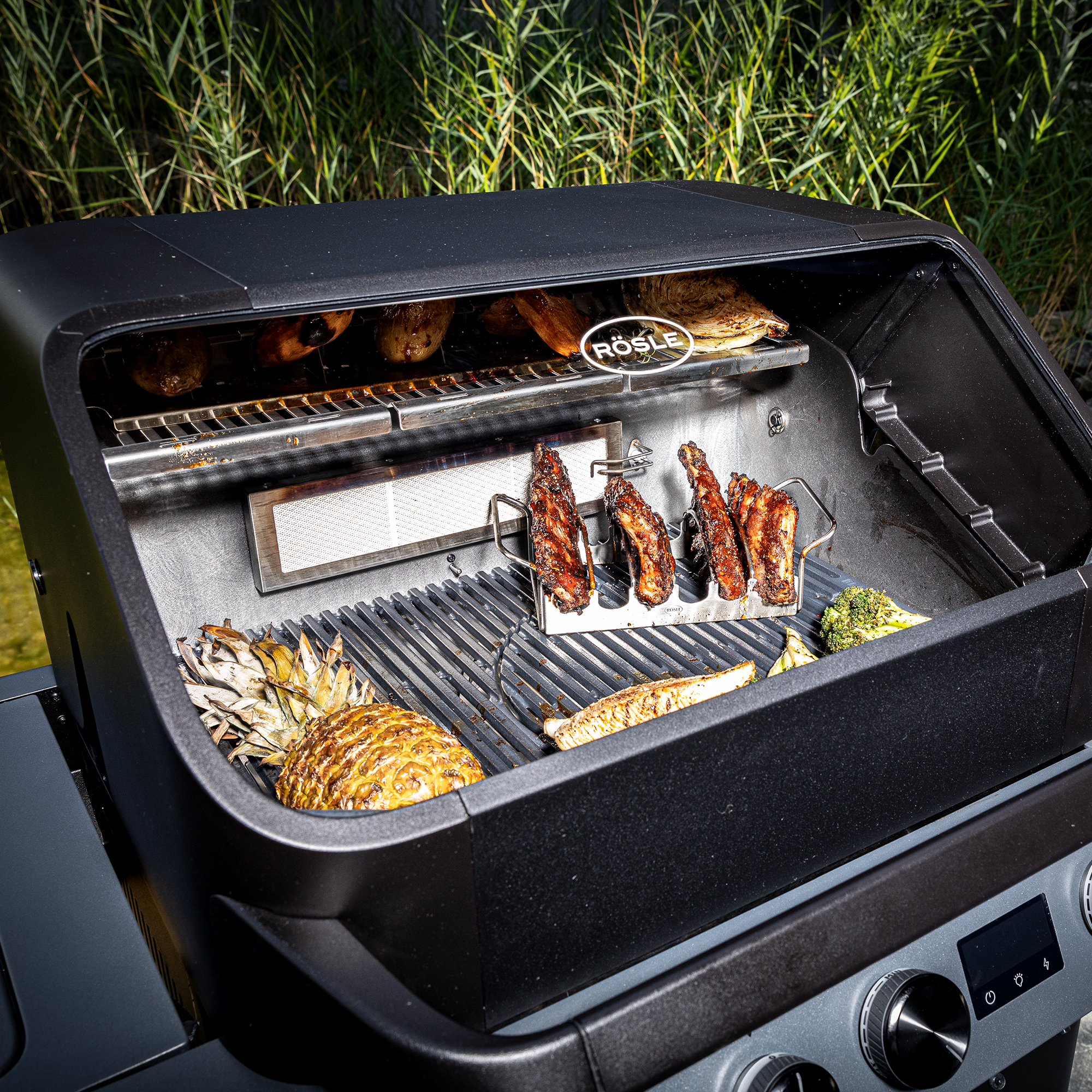 Blazeflame Master Grill mit Grillgut wie Hähnchen, Ananas und Gemüse auf dem Rost.