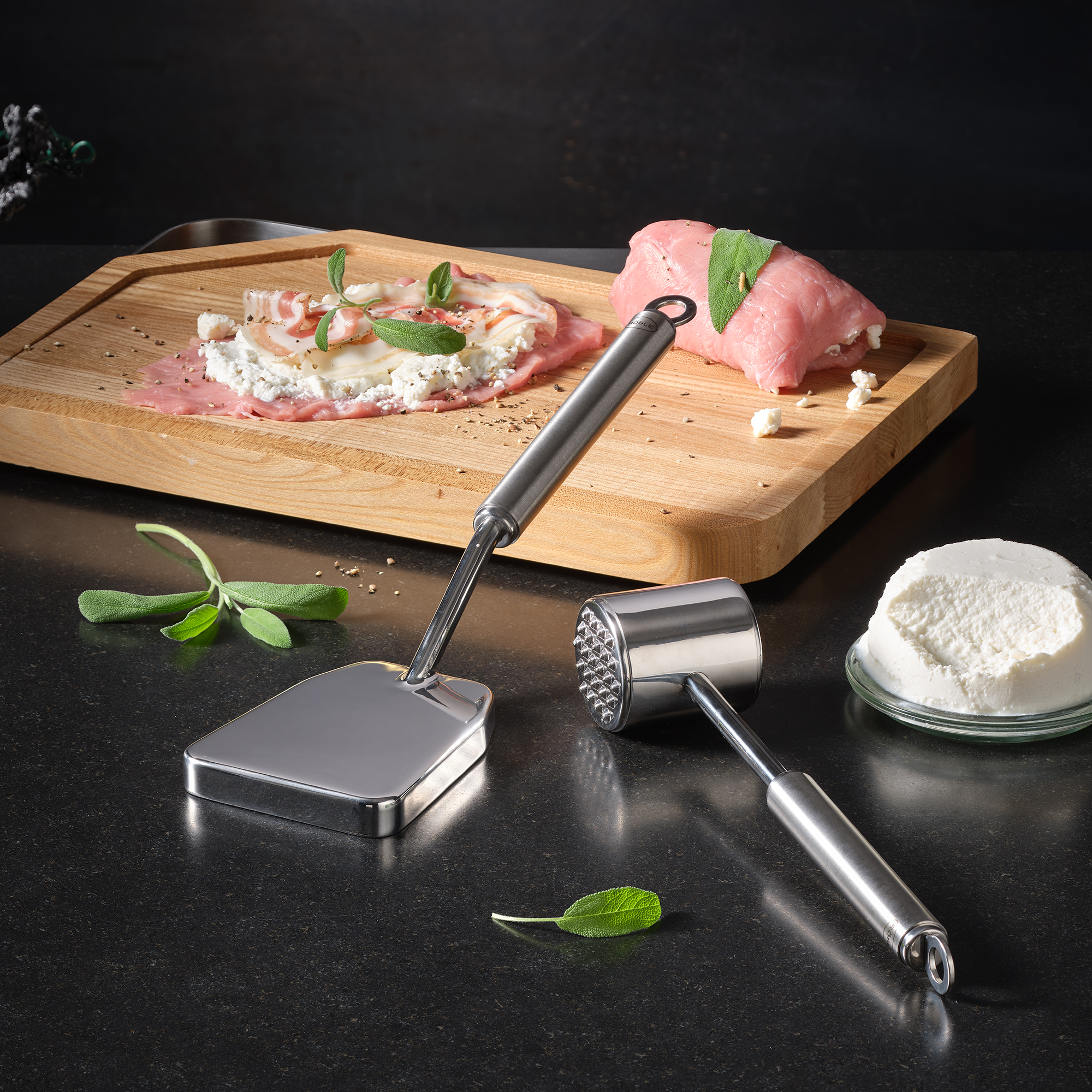 RÖSLE meat hammer and stuffed meat on wooden platter Stainless steel meat hammer with flat and hammered side, next to a wooden platter with stuffed...