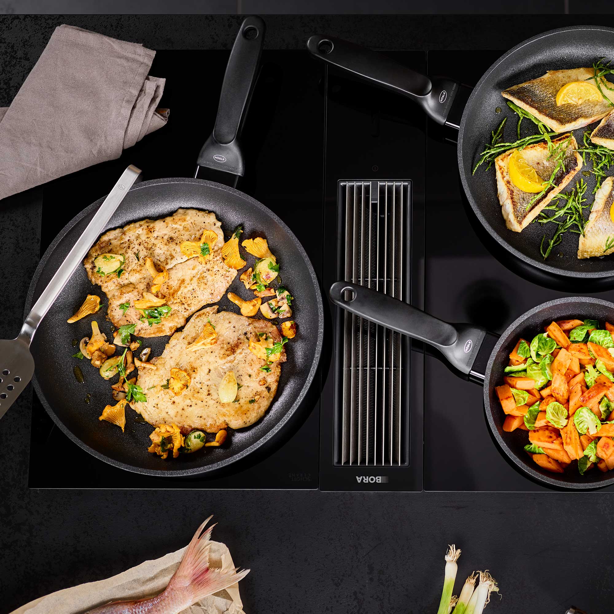 RÖSLE Bratpfanne Cadini 32 cm Bratpfanne Cadini 32 cm mit gebratenem Fleisch und Gemüse auf einem Kochfeld.