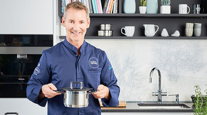 Brand ambassador Christian Henze in the kitchen with SILENCE PRO series cooking pot in hand.