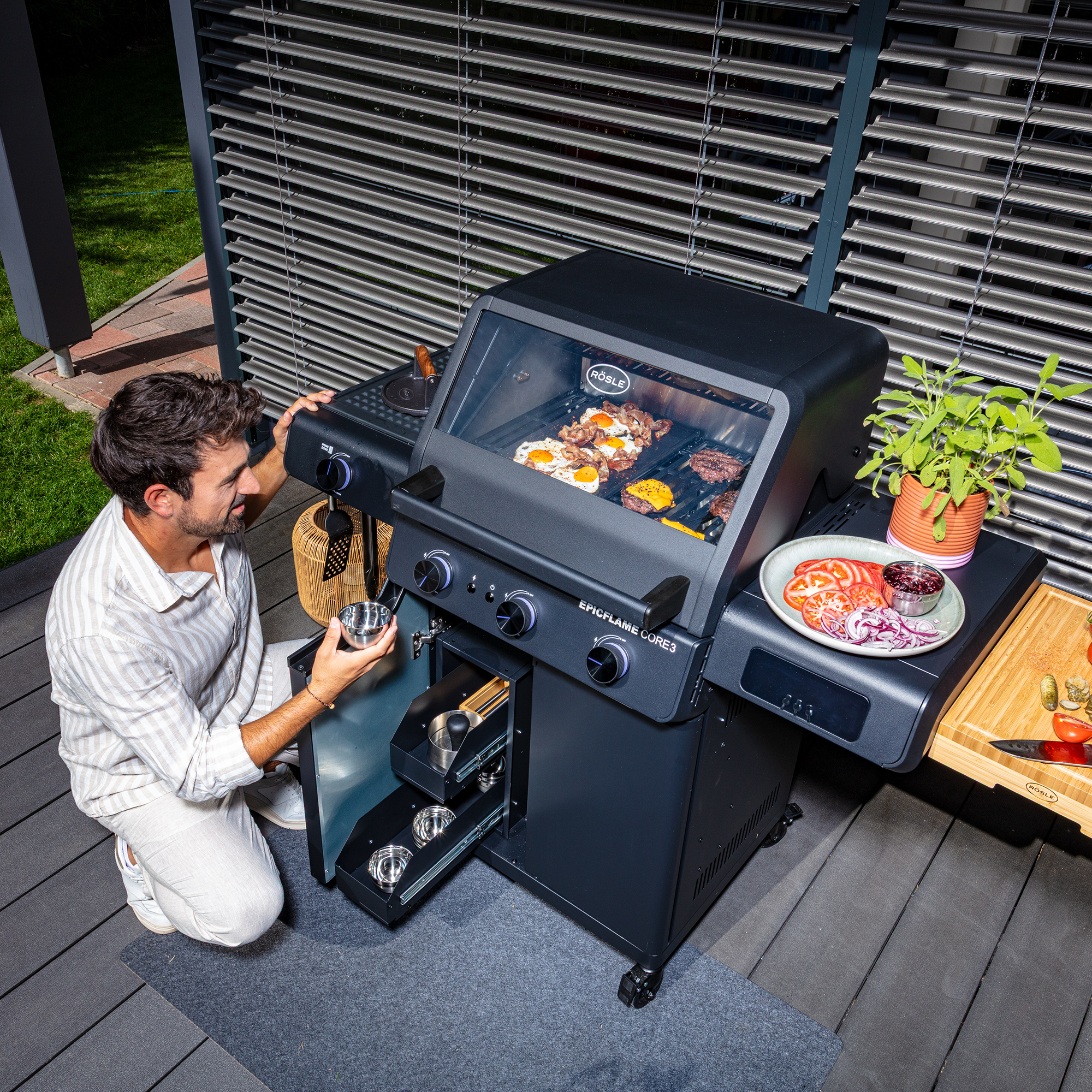RÖSLE EPICFLAME Core 3 Gasgrill EPICFLAME Core 3 Grill, ein Mann ist vor dem Schubladenauszug und entnimmt eine Schale