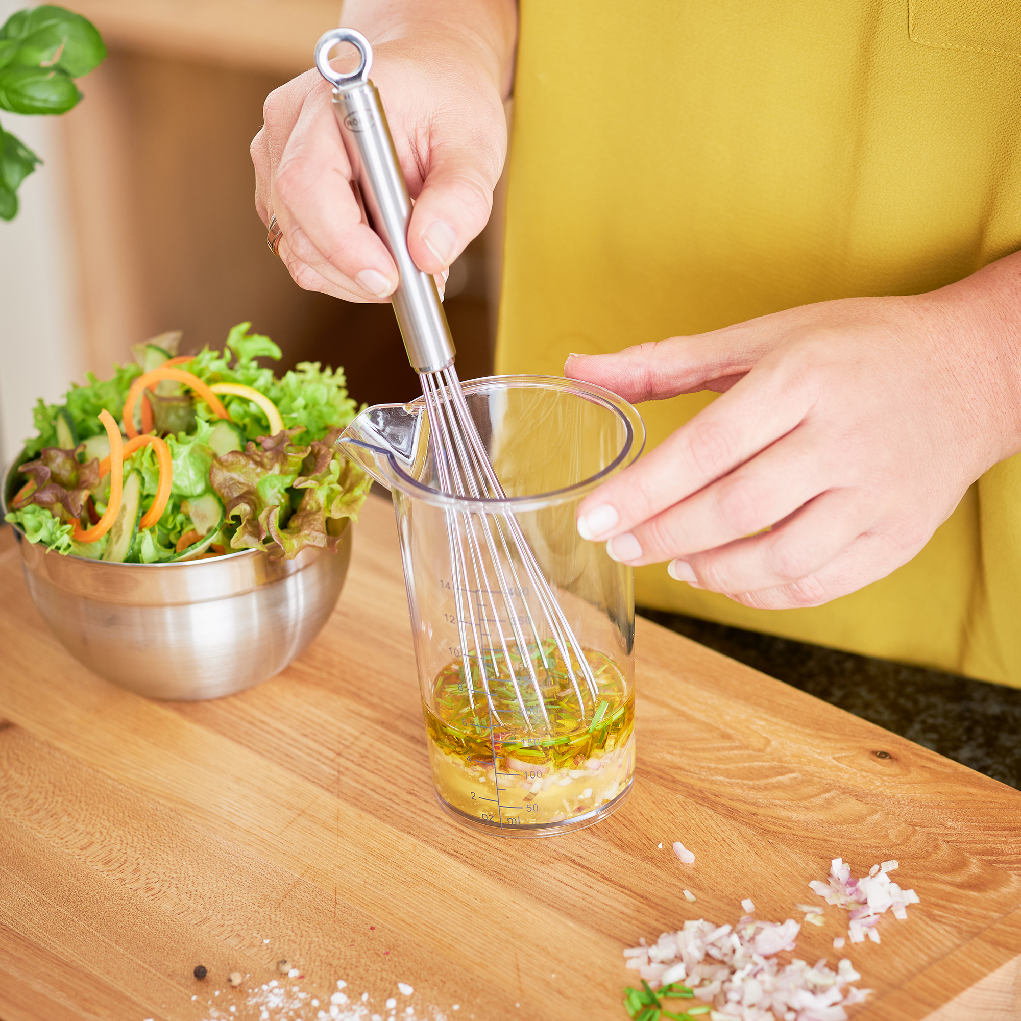 RÖSLE cup broom in action Stainless steel beaker whisk, 27 cm, is used for mixing ingredients in a measuring beaker.