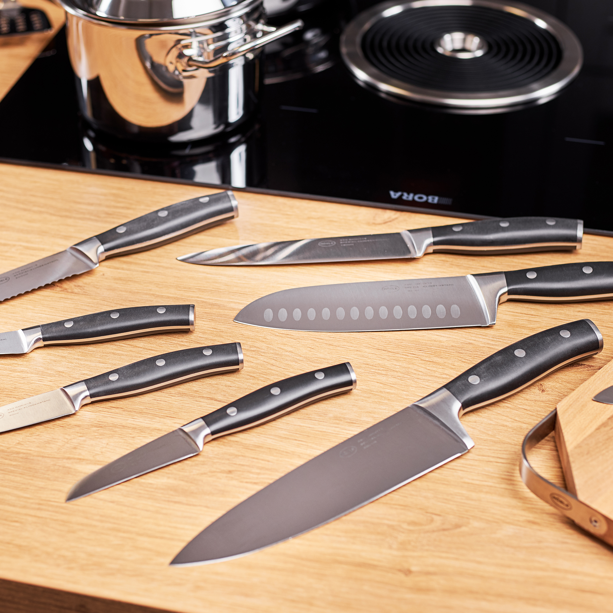 RÖSLE Küchenmesser Set Kochmesser Tradition 20 cm und weitere Küchenmesser auf einem Holzbrett.