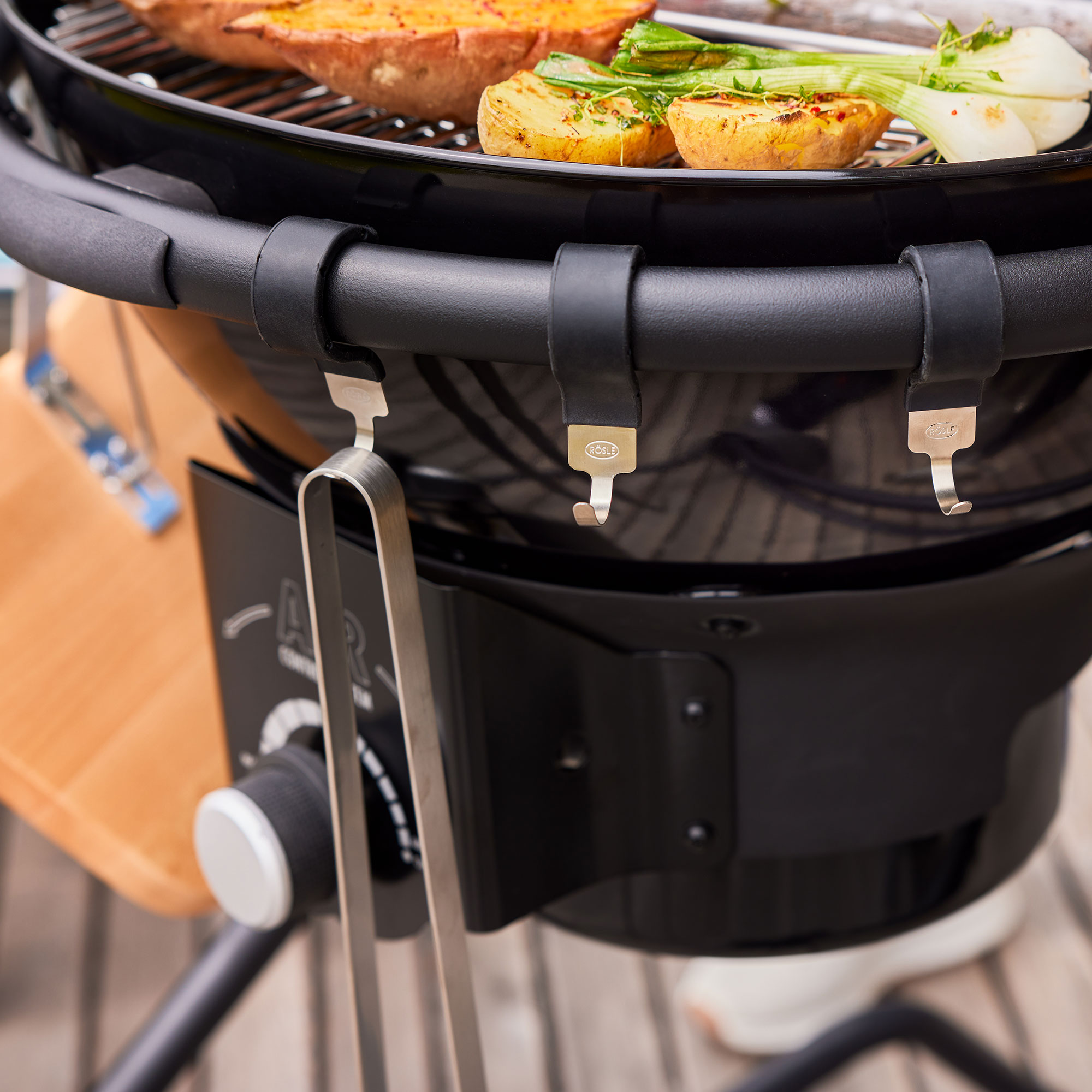 RÖSLE Holzkohlegrill AIR F50 PRO Holzkohlegrill AIR F50 PRO mit Grillgut, Halterungen für Grillwerkzeuge und Bedienelementen.
