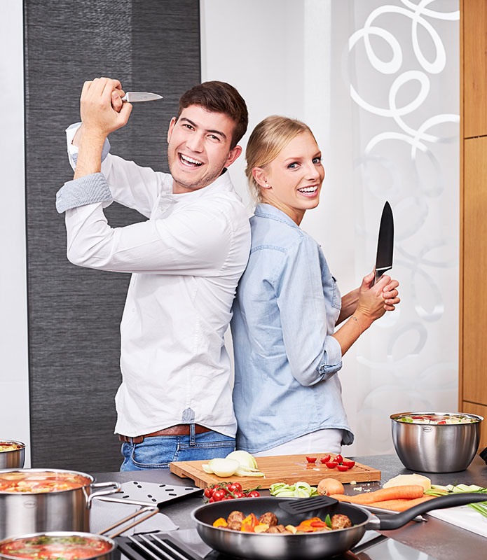 Basic Line Pärchen steht Rücken an Rücken mit Messern der Serie Basic Line in der Hand