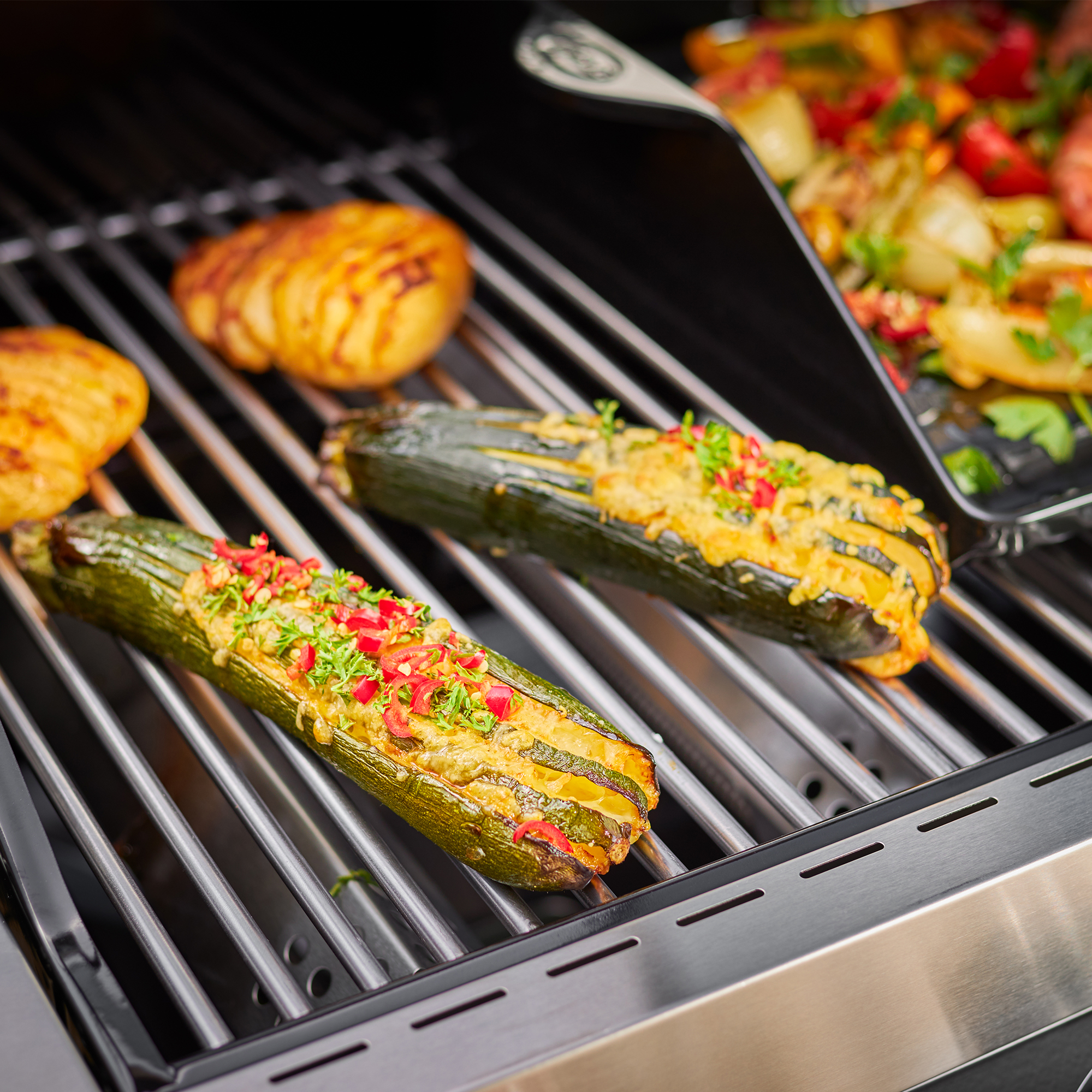 Edelstahl Grillrost mit gefüllten Zucchini Edelstahl Grillrost mit gefüllten Zucchini und Gemüse auf dem Grill.