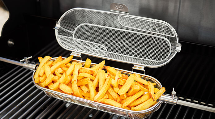 French fries in the rotating spit basket on the grill