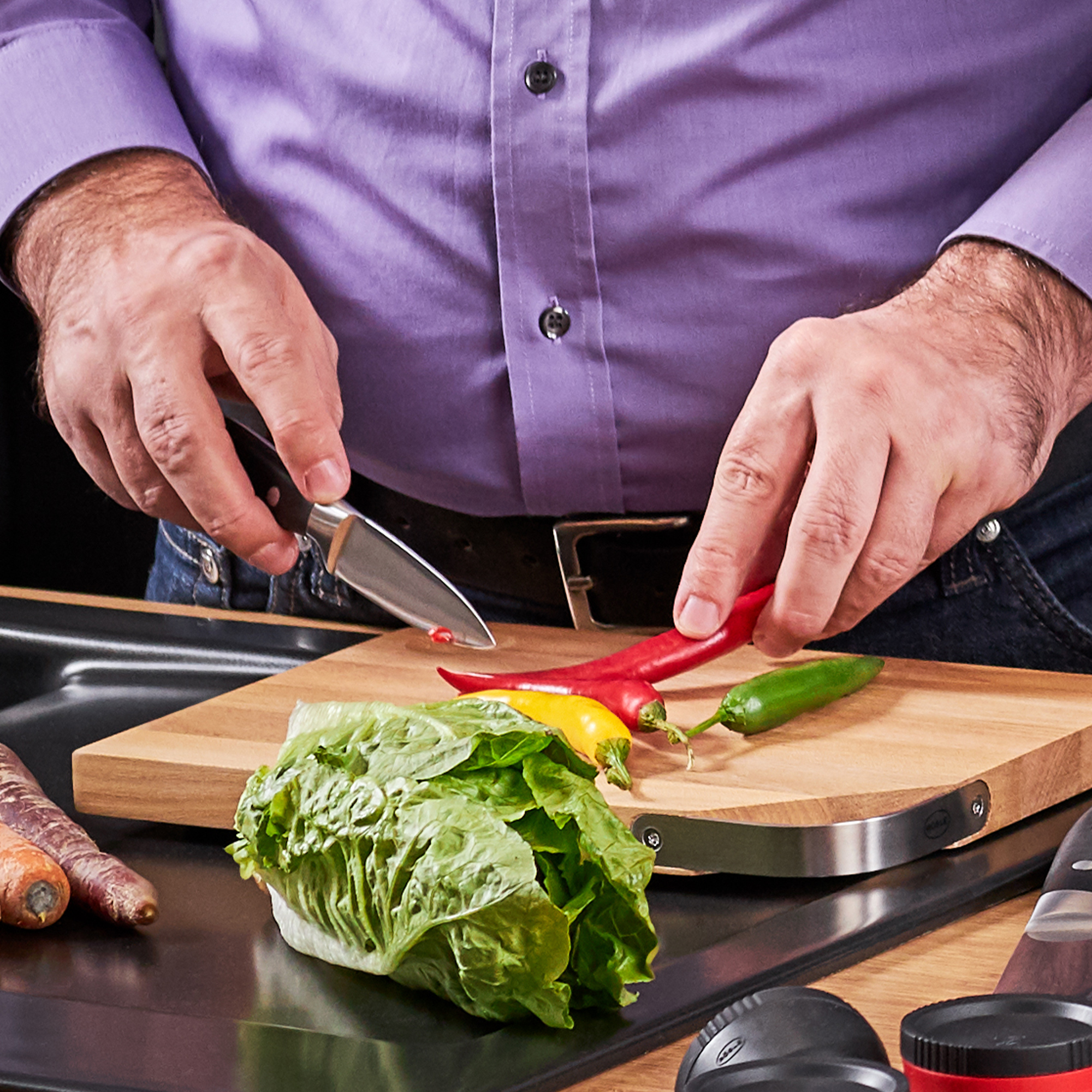 RÖSLE Spickmesser in Aktion Spickmesser, 9 cm, wird von einer Person zum Schneiden von Paprika und Gemüse auf einem Holzbrett...