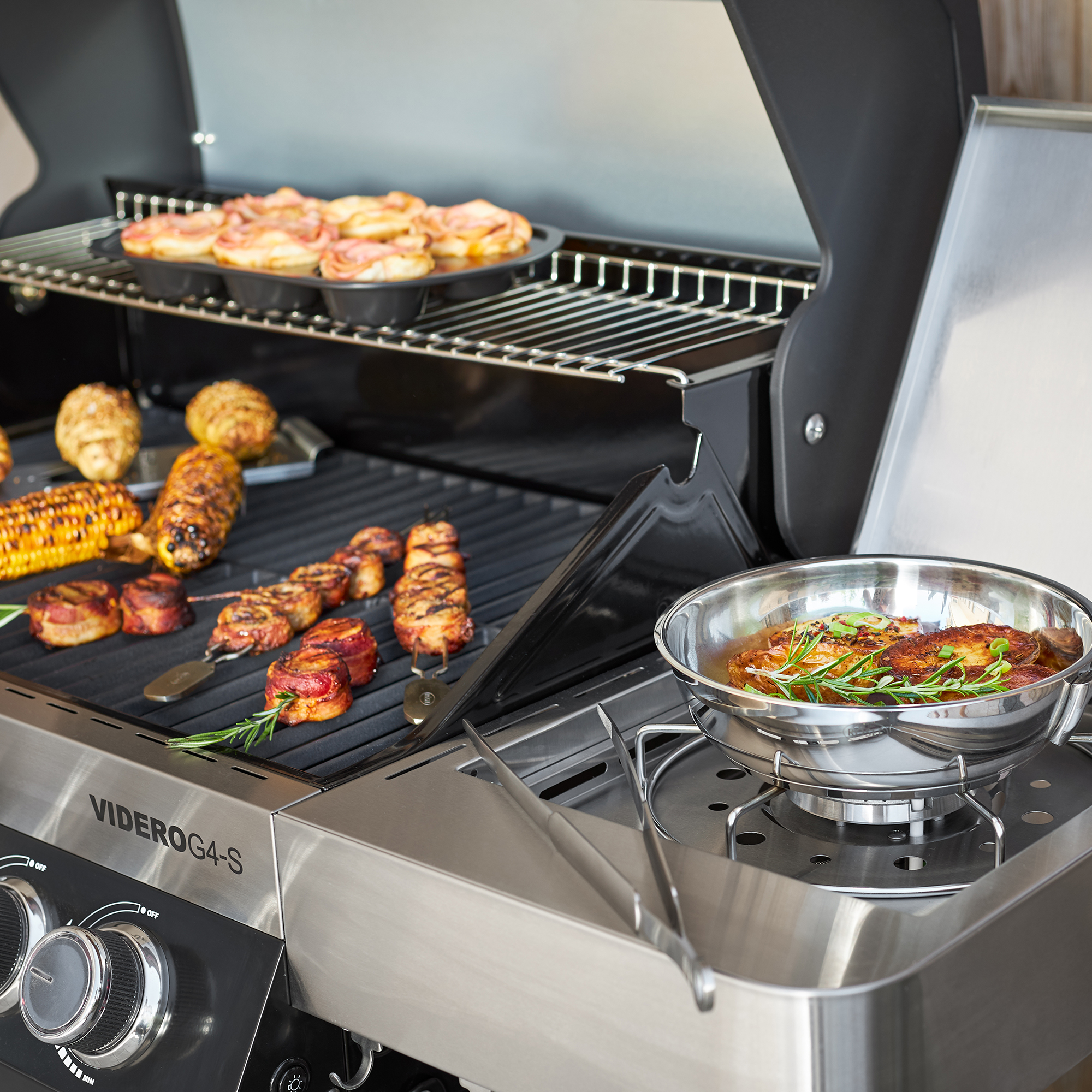 RÖSLE Videro G4-S Gasgrill Gasgrill Videro G4-S in Schwarz mit Grillgut und Grillpfanne.