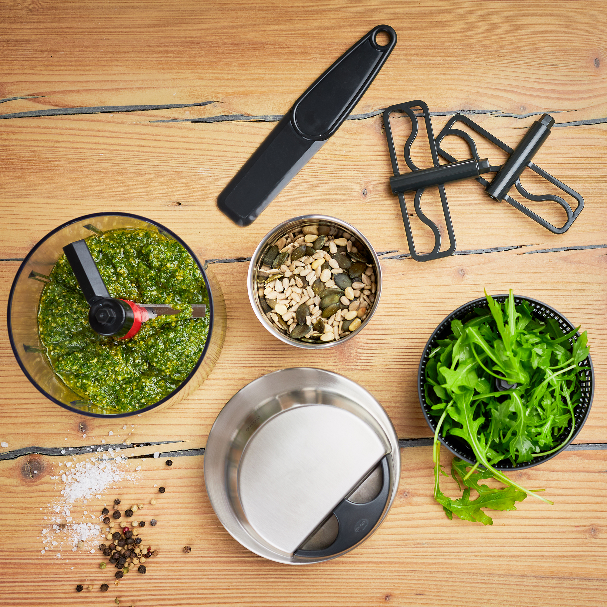 RÖSLE Multischneider und Zutaten Multischneider mit Schüssel, frischem Pesto, Kürbiskernen, Rucola und Küchenwerkzeugen auf...