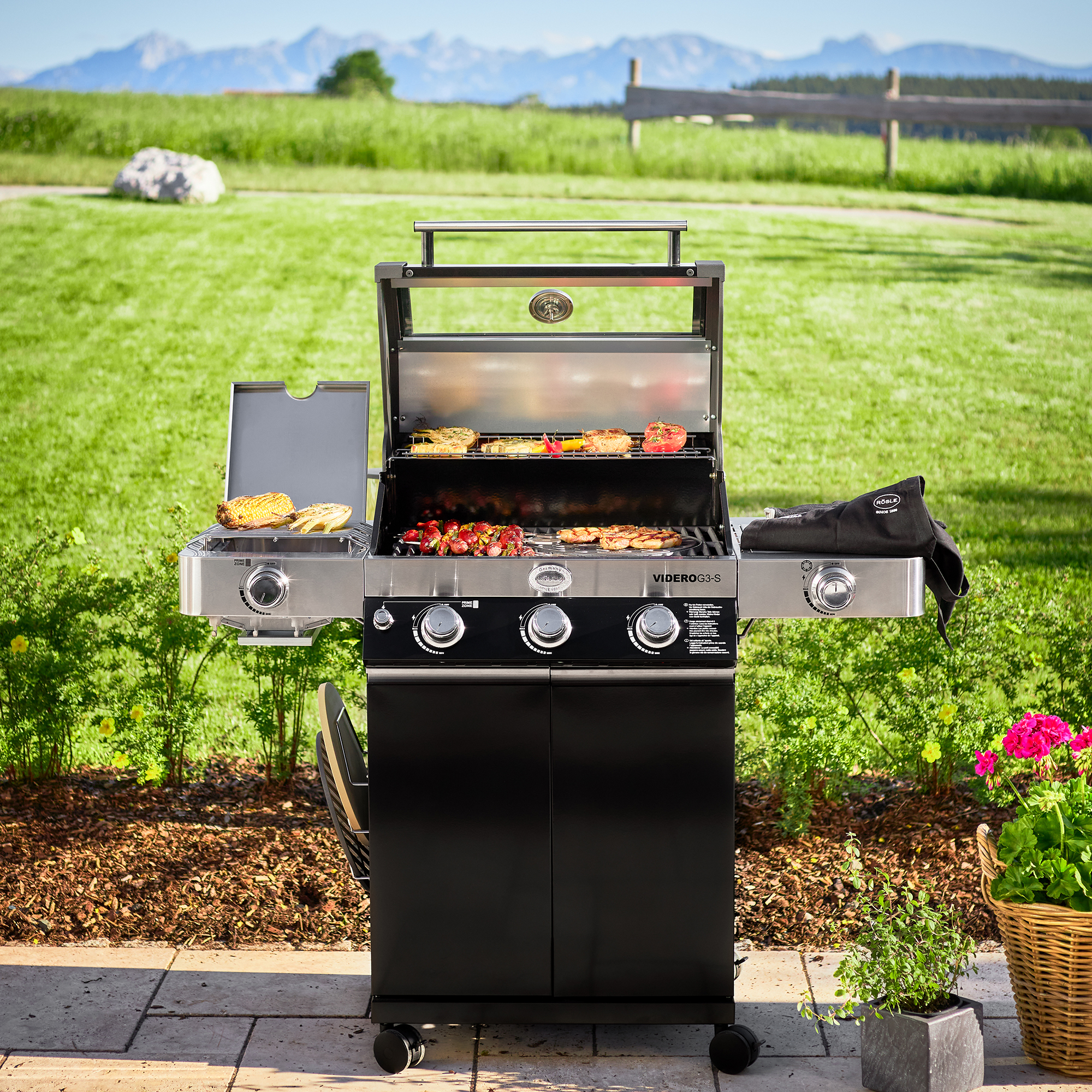 RÖSLE Gasgrill Videro G3-S Gasgrill Videro G3-S in Schwarz mit geöffnetem Deckel, Grillfläche mit Grillgut und seitlichem...