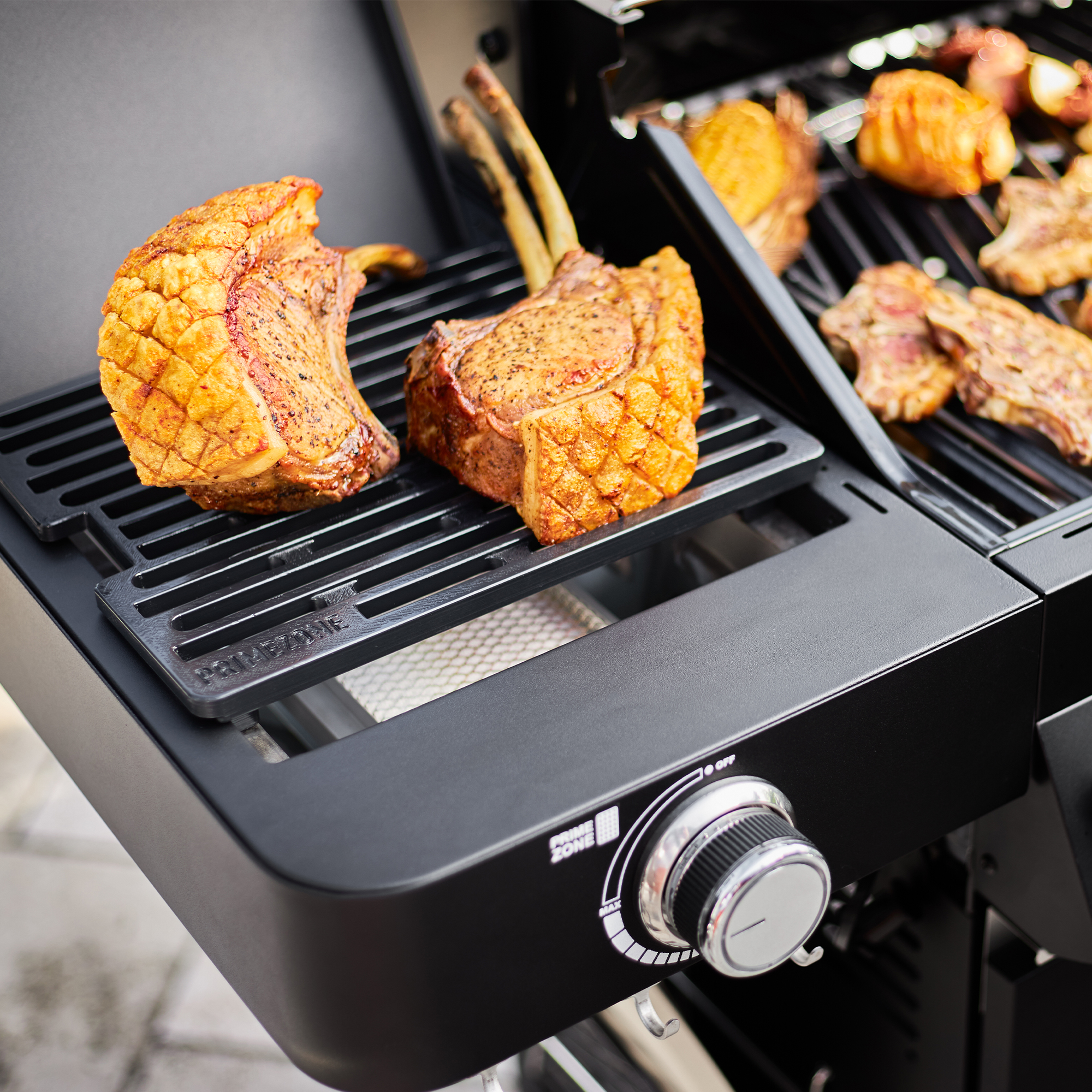 RÖSLE Gasgrill Videro G4-S Vario mit Fleisch Gasgrill BBQ Station Videro G4-S Vario in Schwarz mit gegrilltem Fleisch auf dem Grillrost.