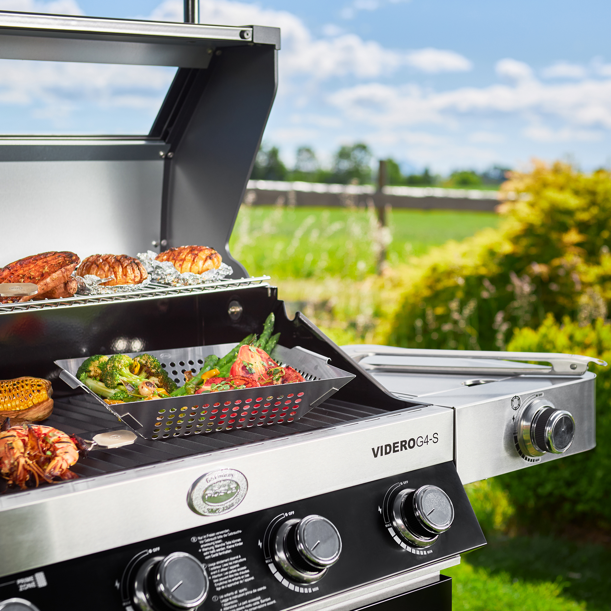 RÖSLE Gasgrill VIDERO G4-S im Freien Gasgrill VIDERO G4-S in Schwarz mit Grillgut wie Gemüse und Fleisch auf dem Rost, im Freien...