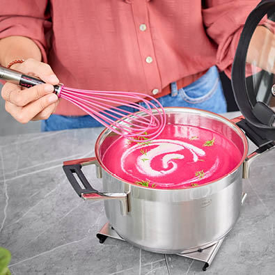 Pinke Rote-Beete-Suppe im Kochtopf Silence Pro 24cm wird mit Schneebesen Pink Charity umgerührt