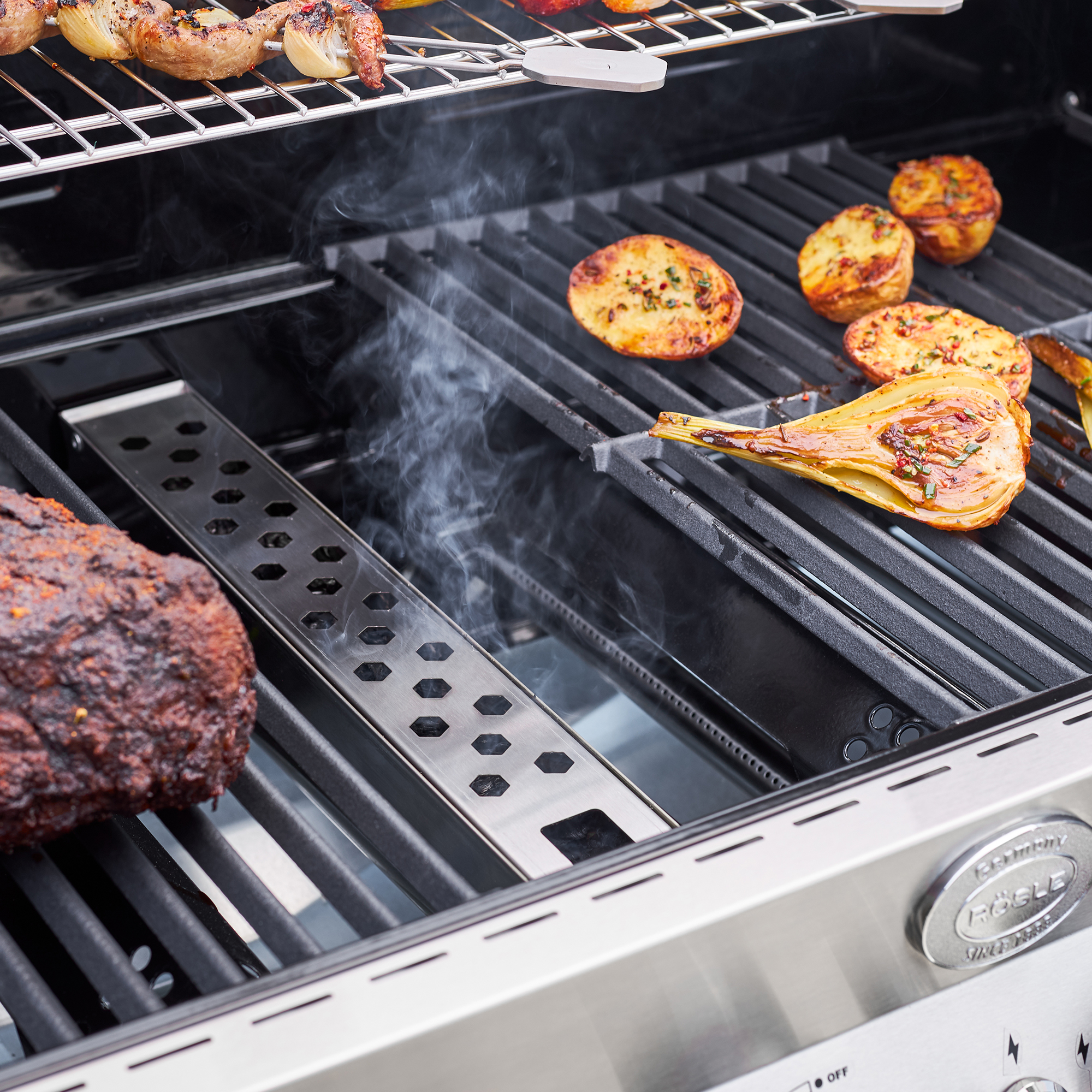 RÖSLE Edelstahl Räucherbox im Einsatz Edelstahl Räucherbox im Grill mit Fleisch und Gemüse, Rauchentwicklung sichtbar